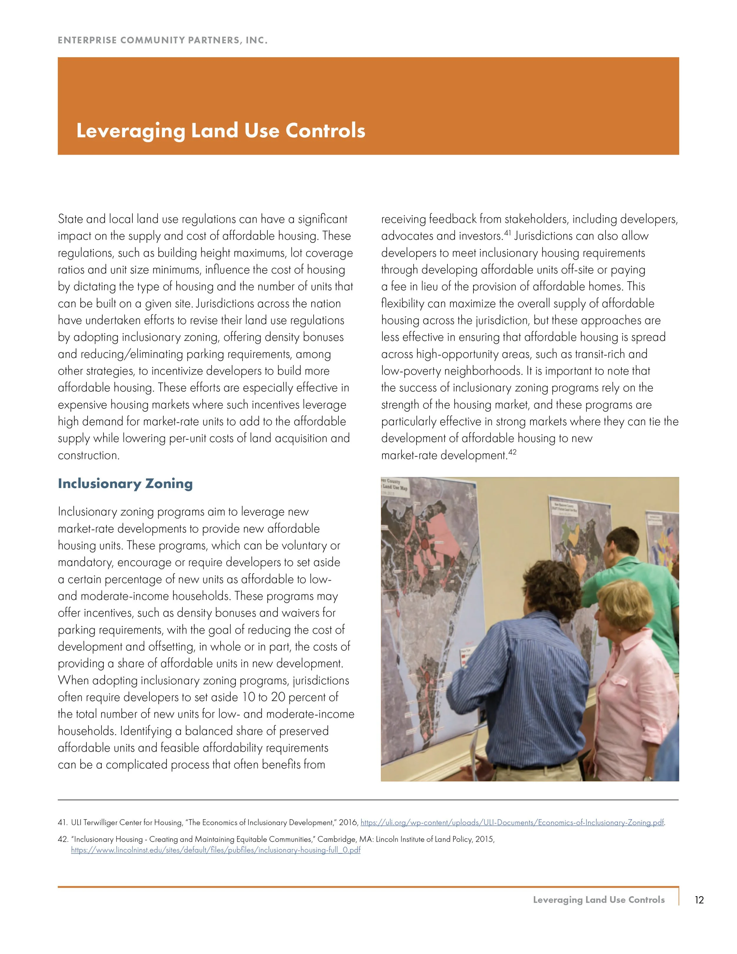 People examining maps and discussing land use at a community planning event.