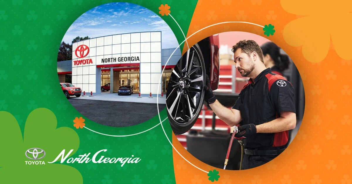 A promotional graphic featuring Toyota North Georgia dealership on the left with a building and cars, and a mechanic inspecting a car's wheel on the right, with a green and orange shamrock-themed background.
