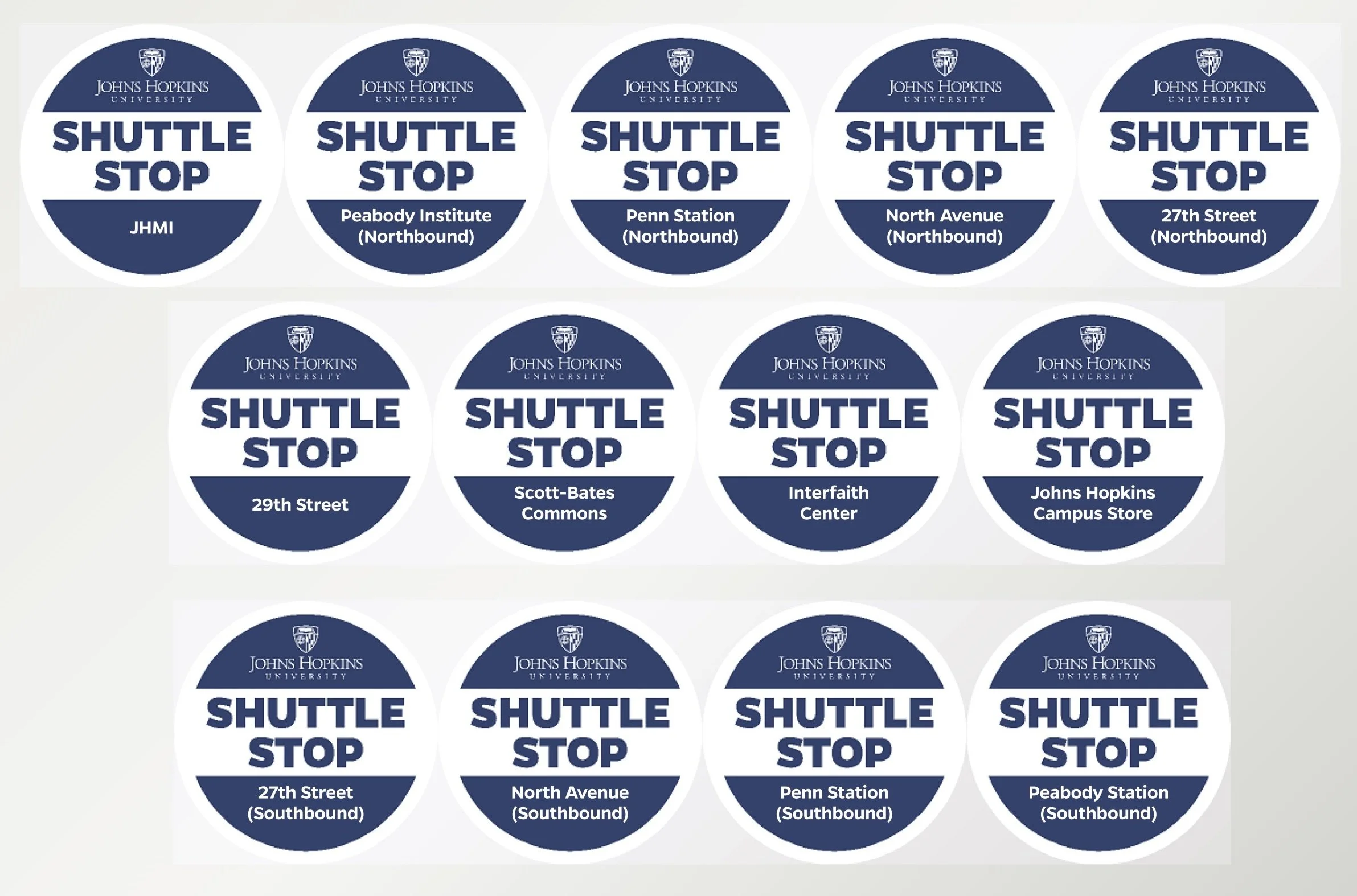 Collection of circular shuttle stop stickers from Johns Hopkins University, indicating bus stops at various locations for northbound and southbound routes, with names such as JHMI, Peabody Institute, Penn Station, North Avenue, 27th Street, 29th Stre