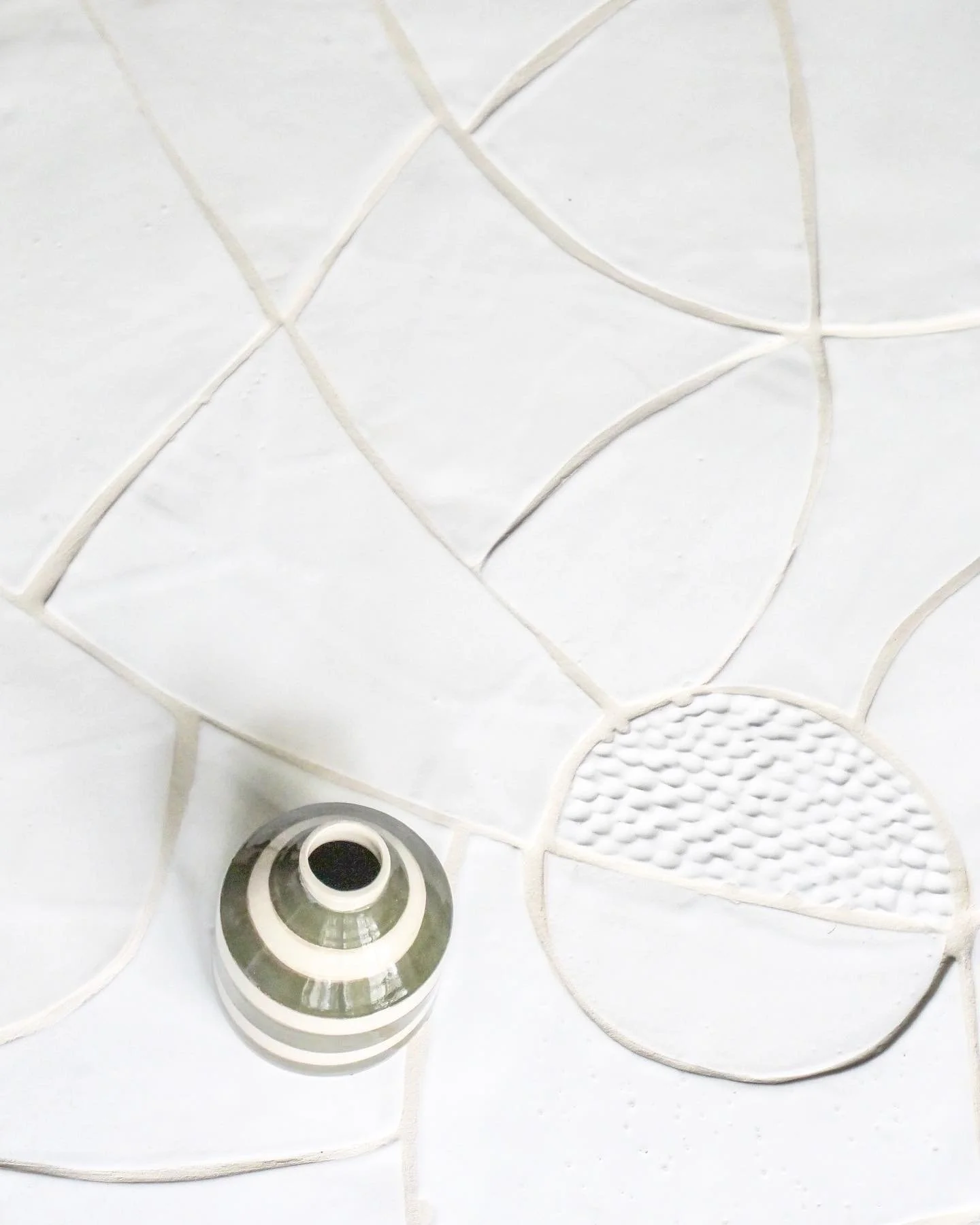 Vase bouteille, gr&egrave;s blanc lisse et d&eacute;cor &agrave; l&rsquo;engobe / &eacute;mail brillant 
- dimensions : ht. 12 / diam. 10

Table en carreaux de fa&iuml;ence blanche / &eacute;mail blanc brillant