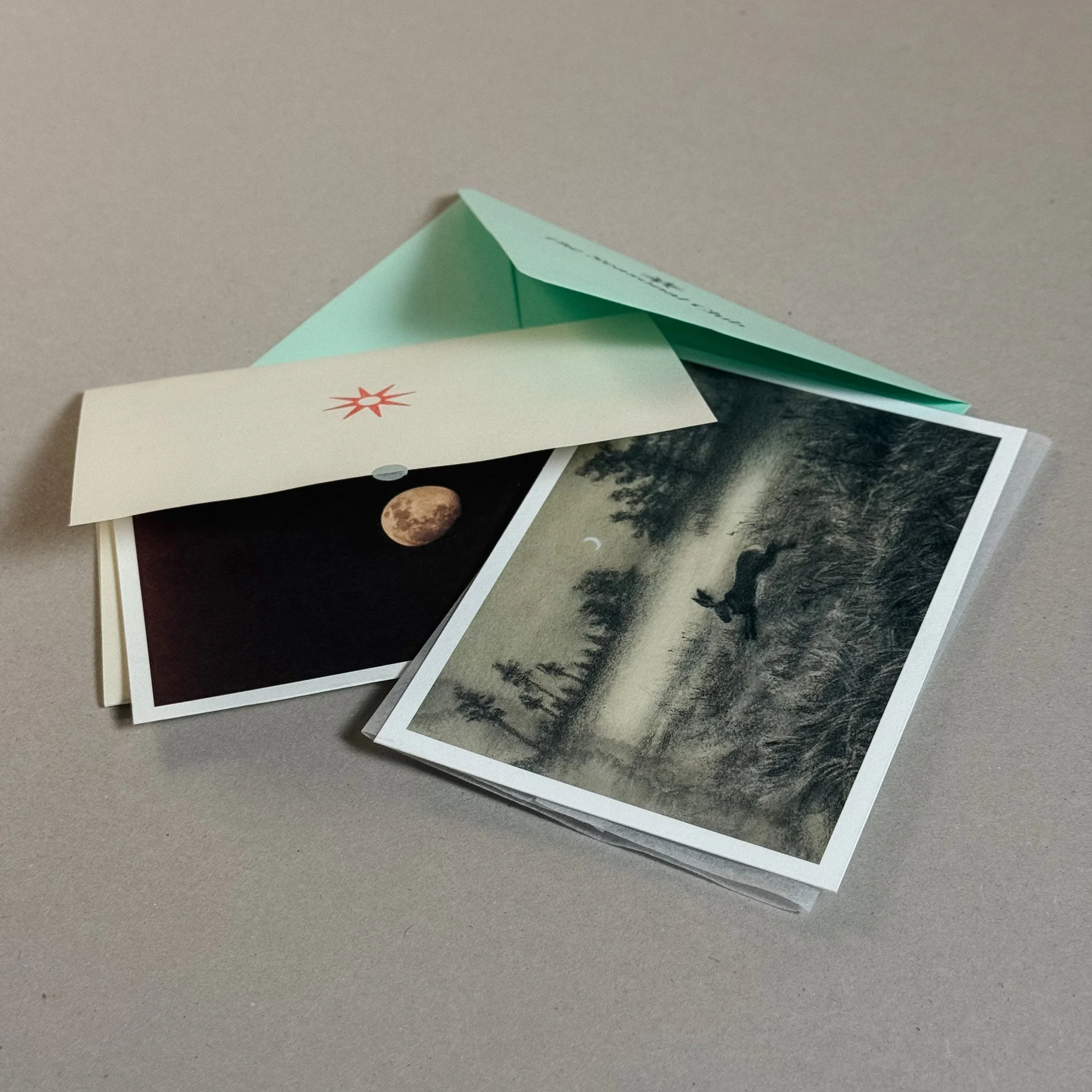 art print of an hare running in the field under the moonlight, a studio letter, and a nature-themed postcard depicting the moon