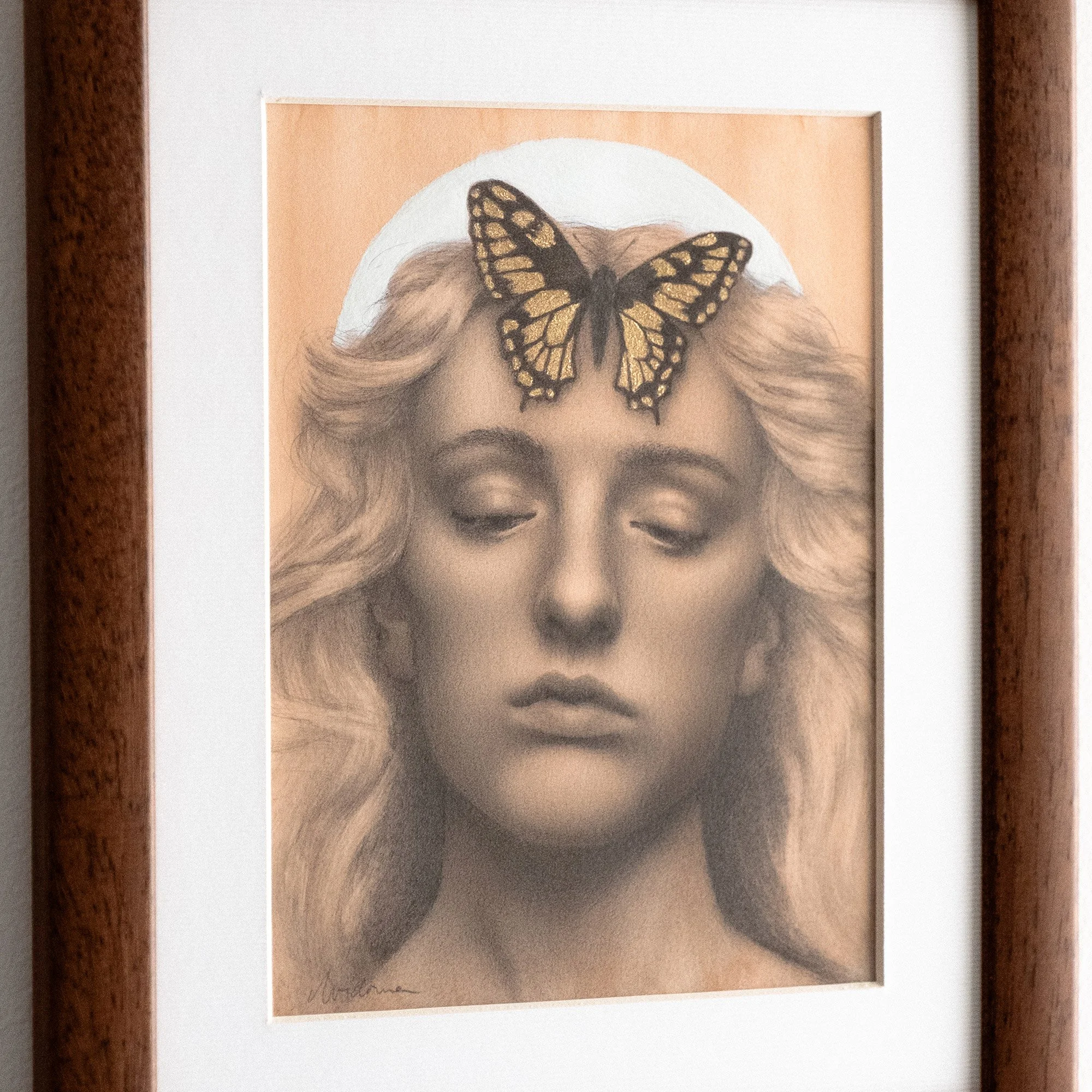 Framed graphite drawing of a feminine portrait with a golden butterfly on the forehead, inspired by Summer Solstice light, transformation, and folklore.