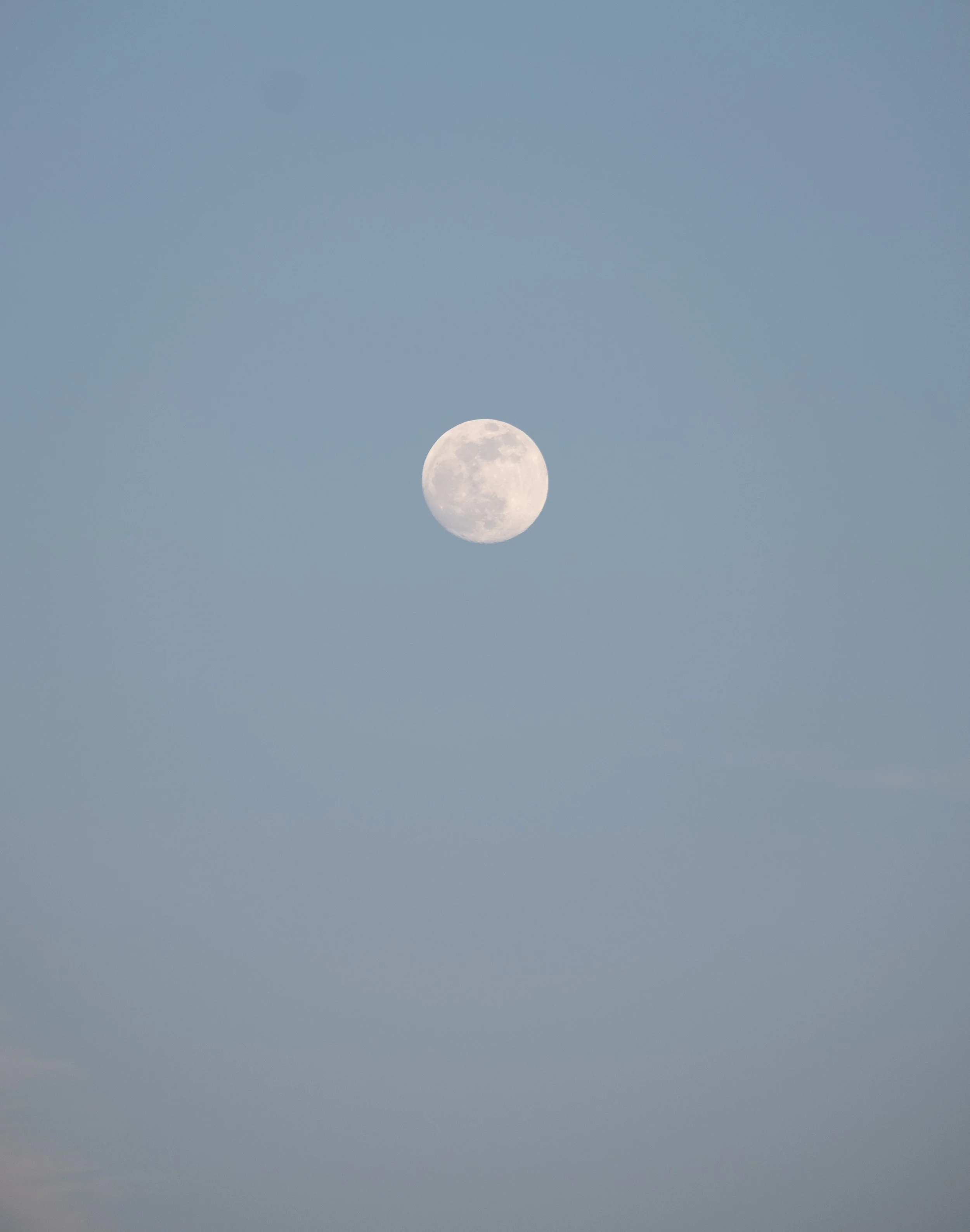 The full moon in a clear blue sky.