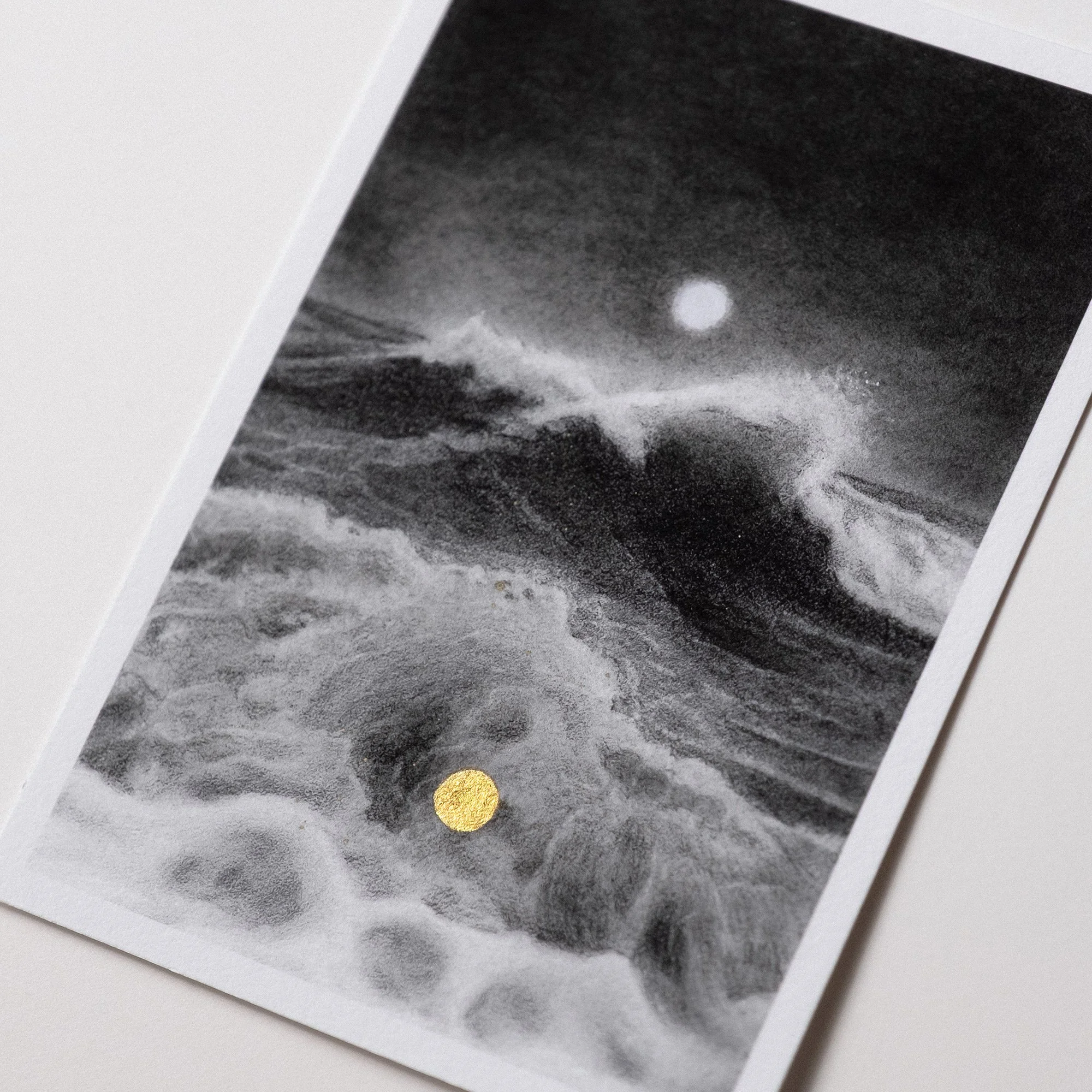 Postcard-sized fine art print from Postcards from Imaginary Places, showing a dreamy ocean wave beneath the moon with a painted gold dot accent.