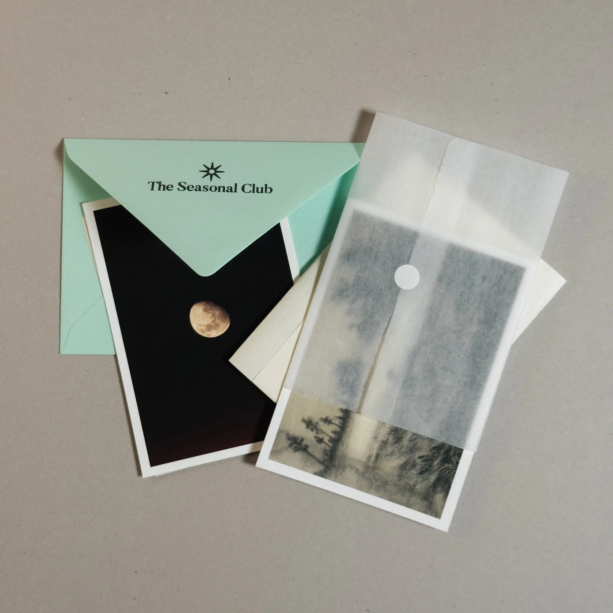 art snail mail subscription showing the content of the envelope, an art print and moon postcard