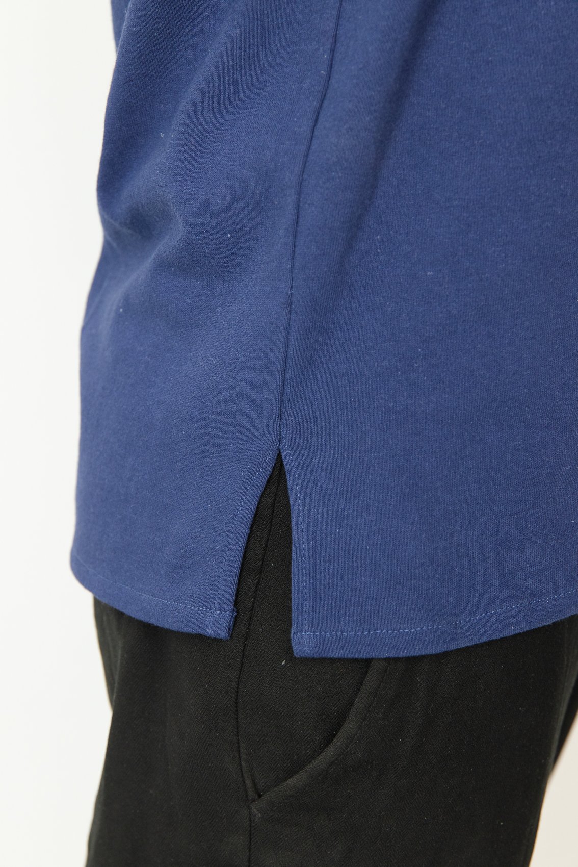 T-shirt médicale bleu avec une fente sur le côté et pantalon noir.