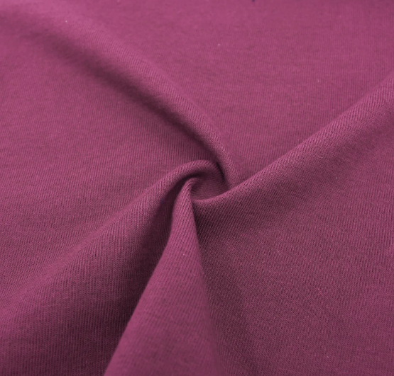 Tissu en coton de couleur rose magenta plissé en un pli à l'avant-plan.