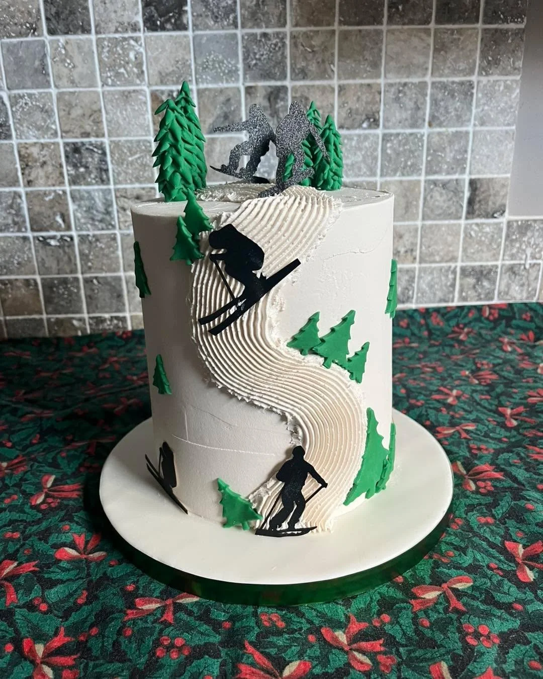 Two separate orders that were picked up before Christmas and enjoyed over the festive period. 

First was a vanilla sponge cake with a simple but effective ski slope piped onto the side. 

Second was a chocolate with with a nicely decorated tree and 