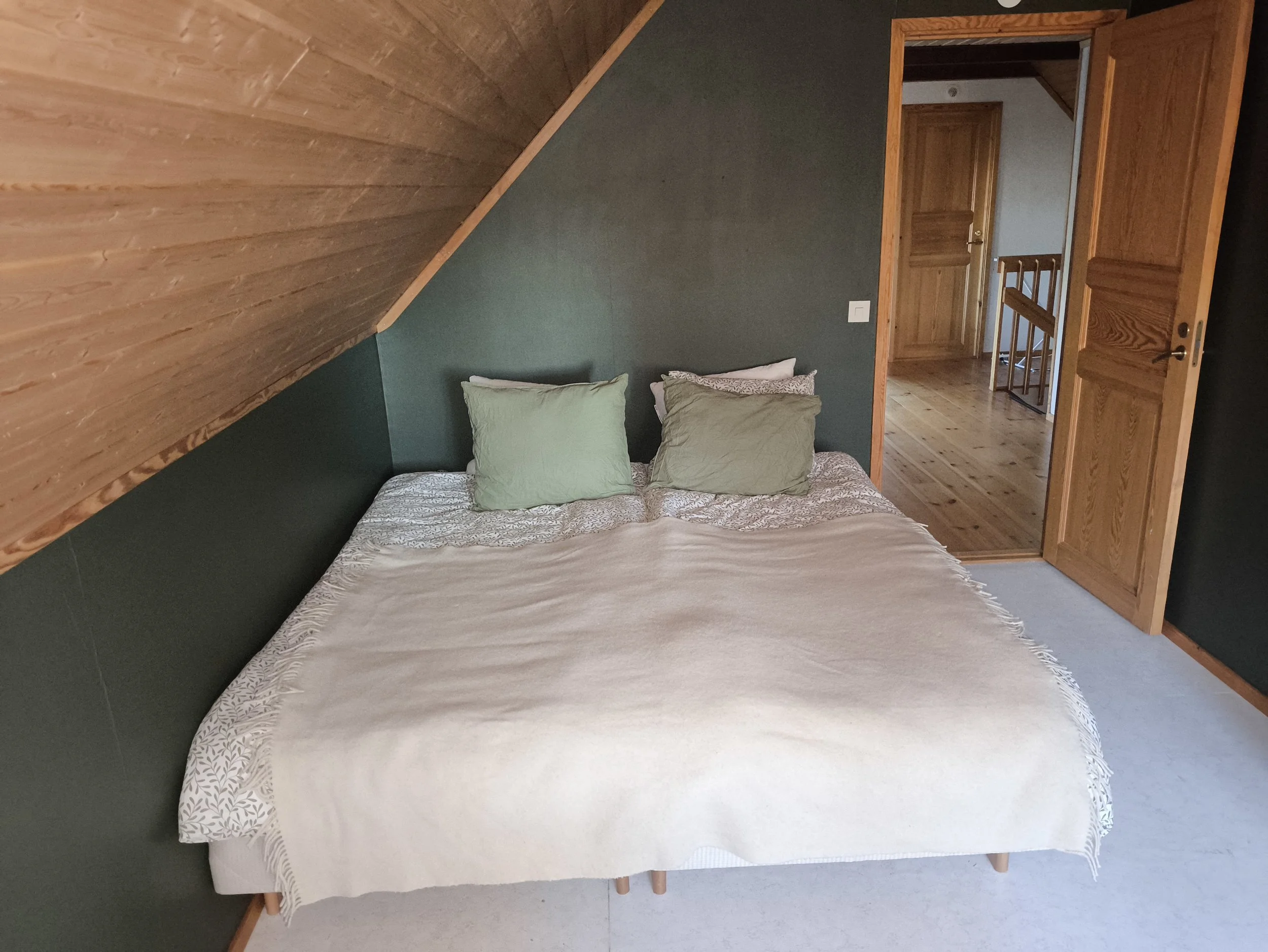 Scandinavian bedroom at West Cottage Sweden with soft lighting and calm natural tones
