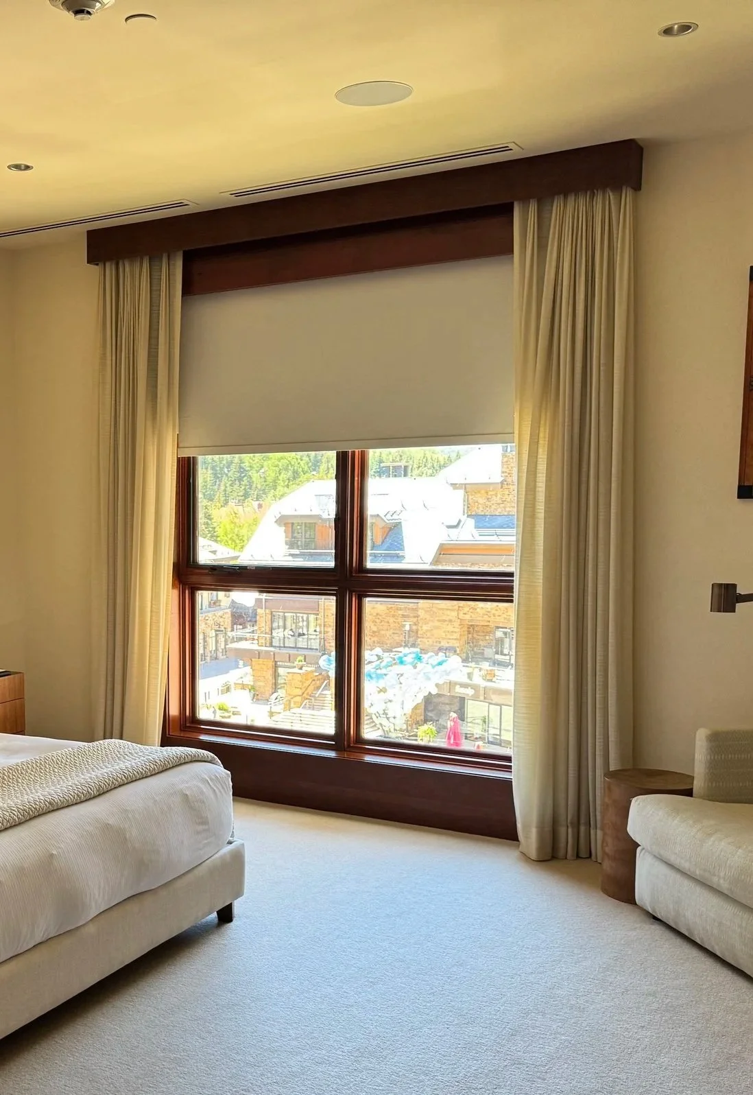 Light Filtering Drapes and a Room Darkening Roller Shade behind a Custom Wood Valance