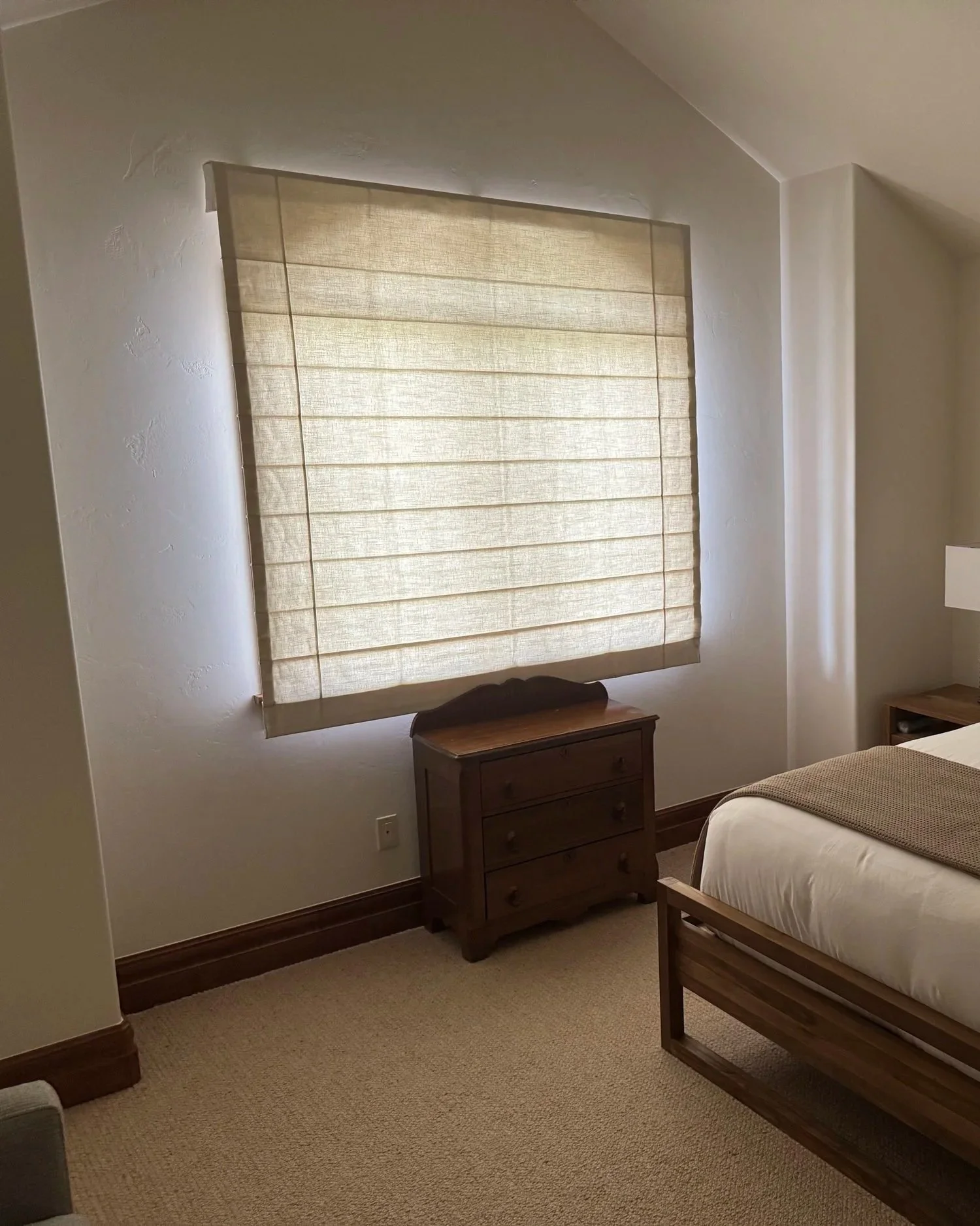 Light Filtering Reverse Fold Roman Shade covering an Arched Window (Closed)