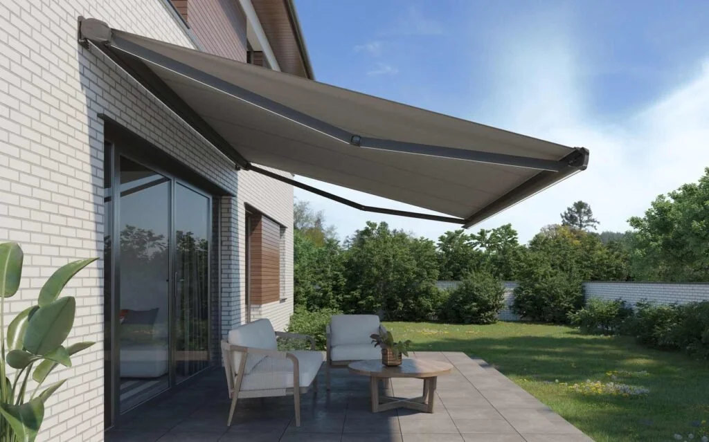 Image of grey outdoor awning extending above a patio on a white brick home.