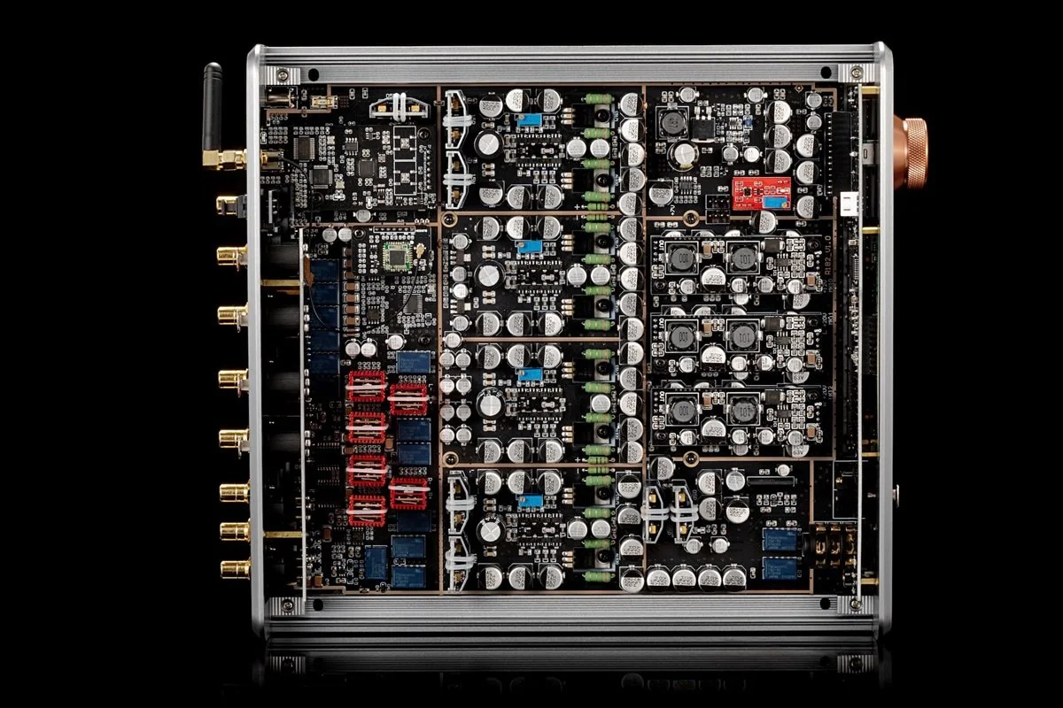 A close-up of a high-end Burson audio amplifier showing intricate internal electronic components including capacitors, resistors, circuit boards, and gold-plated connectors.