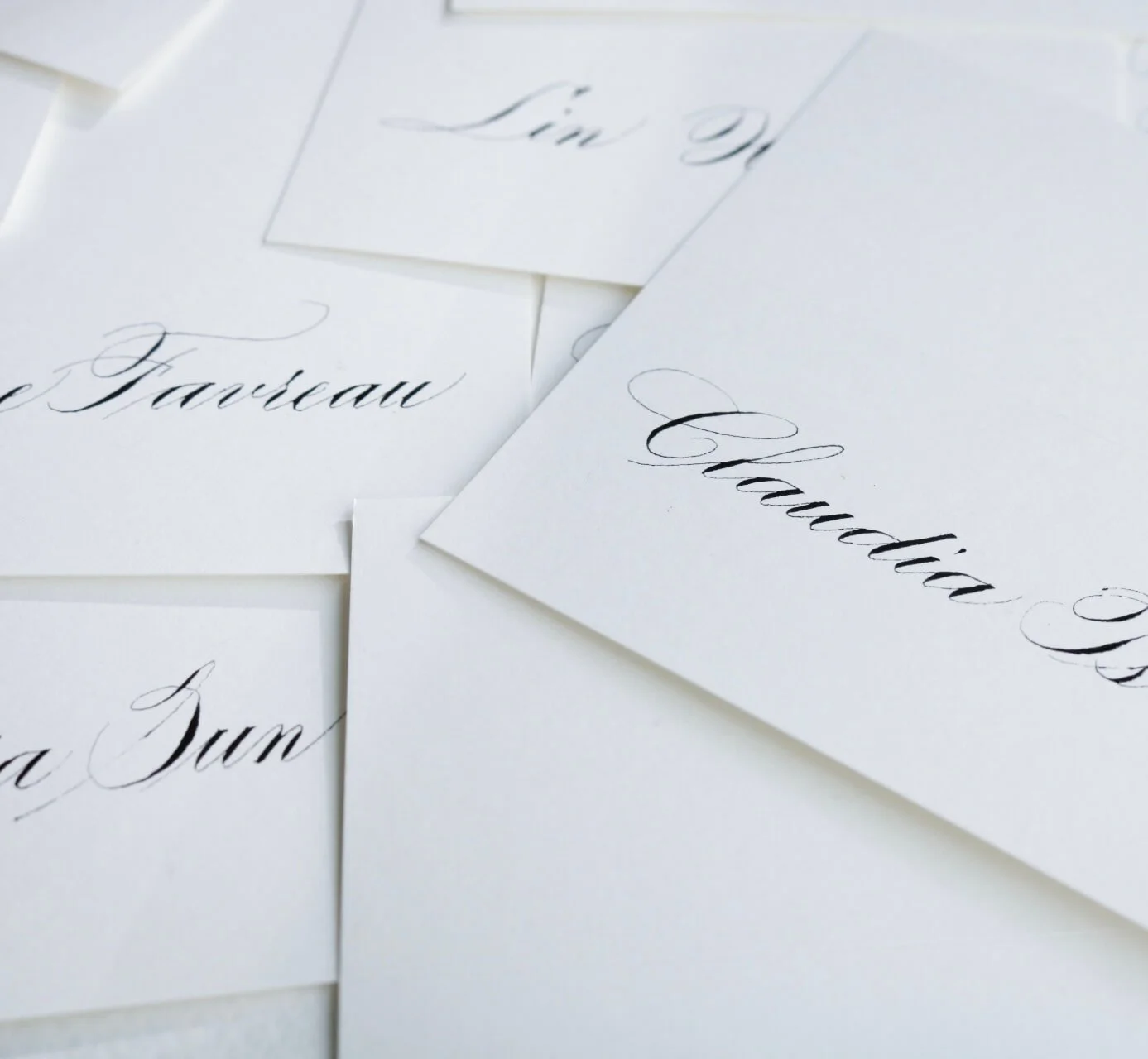 Multiple white cards with names written in traditional script style.
