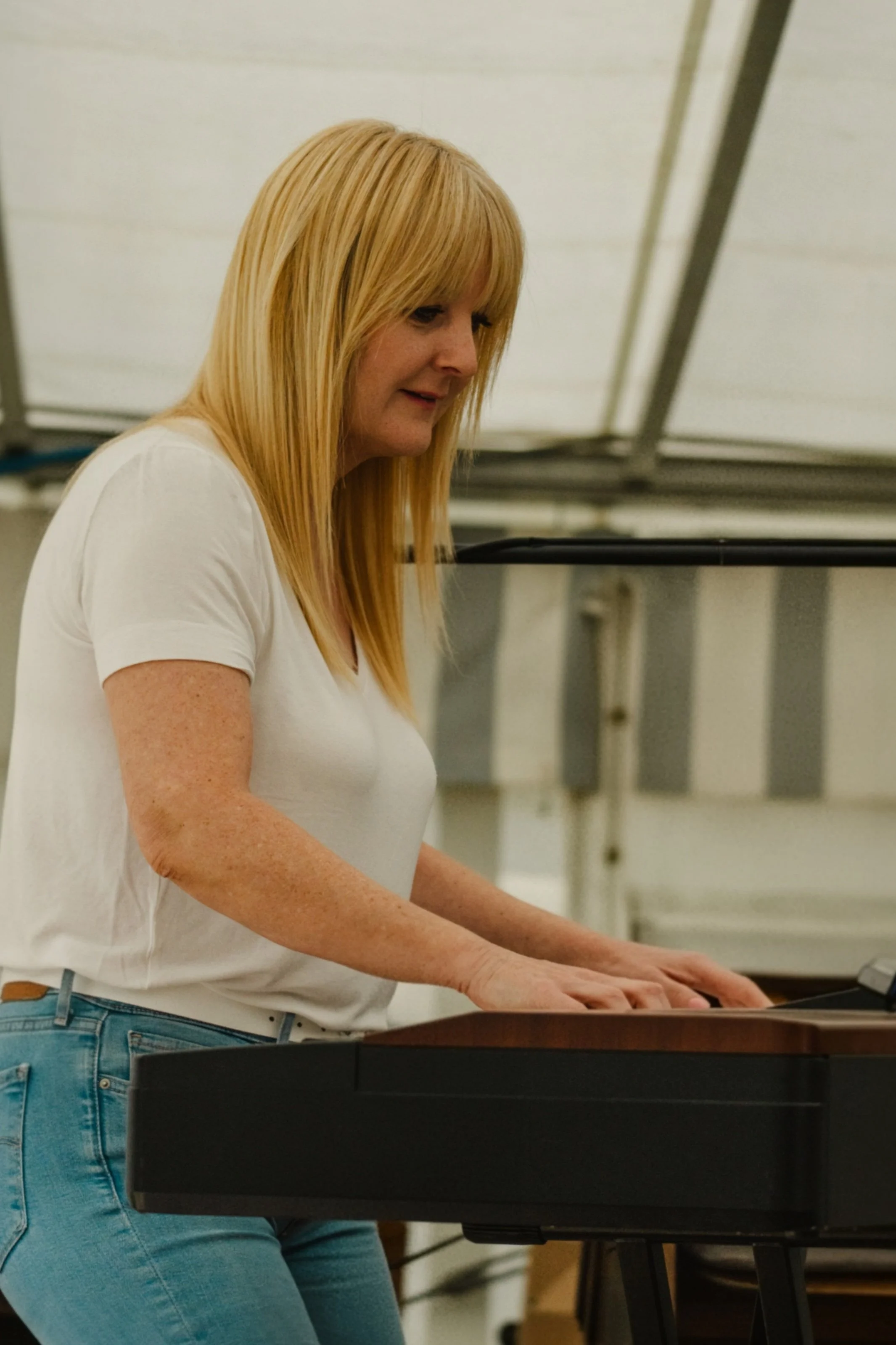 Frau spielt E-Piano auf einer Bühne in einem Festzelt.