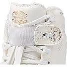 Close-up of white baby sneakers with Velcro straps and decorative patches