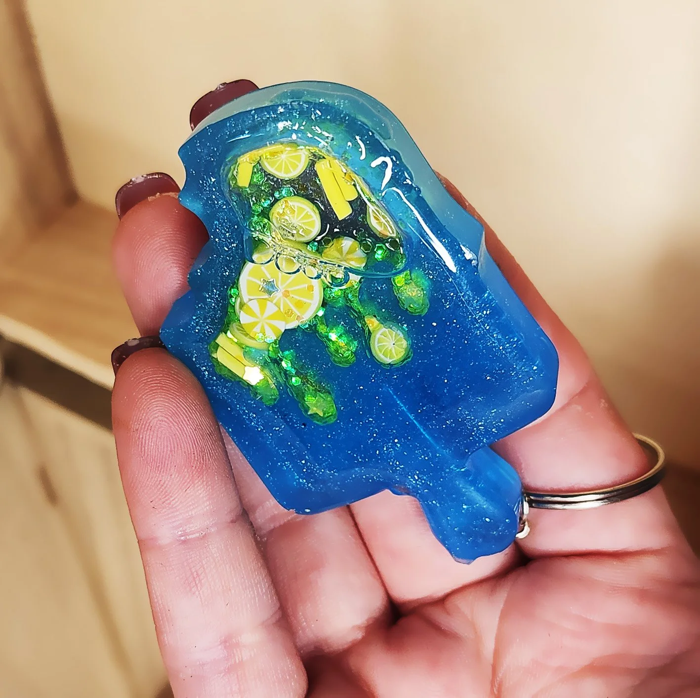 Lemon popsicle wet shaker keychain
Blue resin popsicle with clear resin sealer top, filled with foam citrus slices, foam sprinkles, and glitter (inner liquid is baby oil)