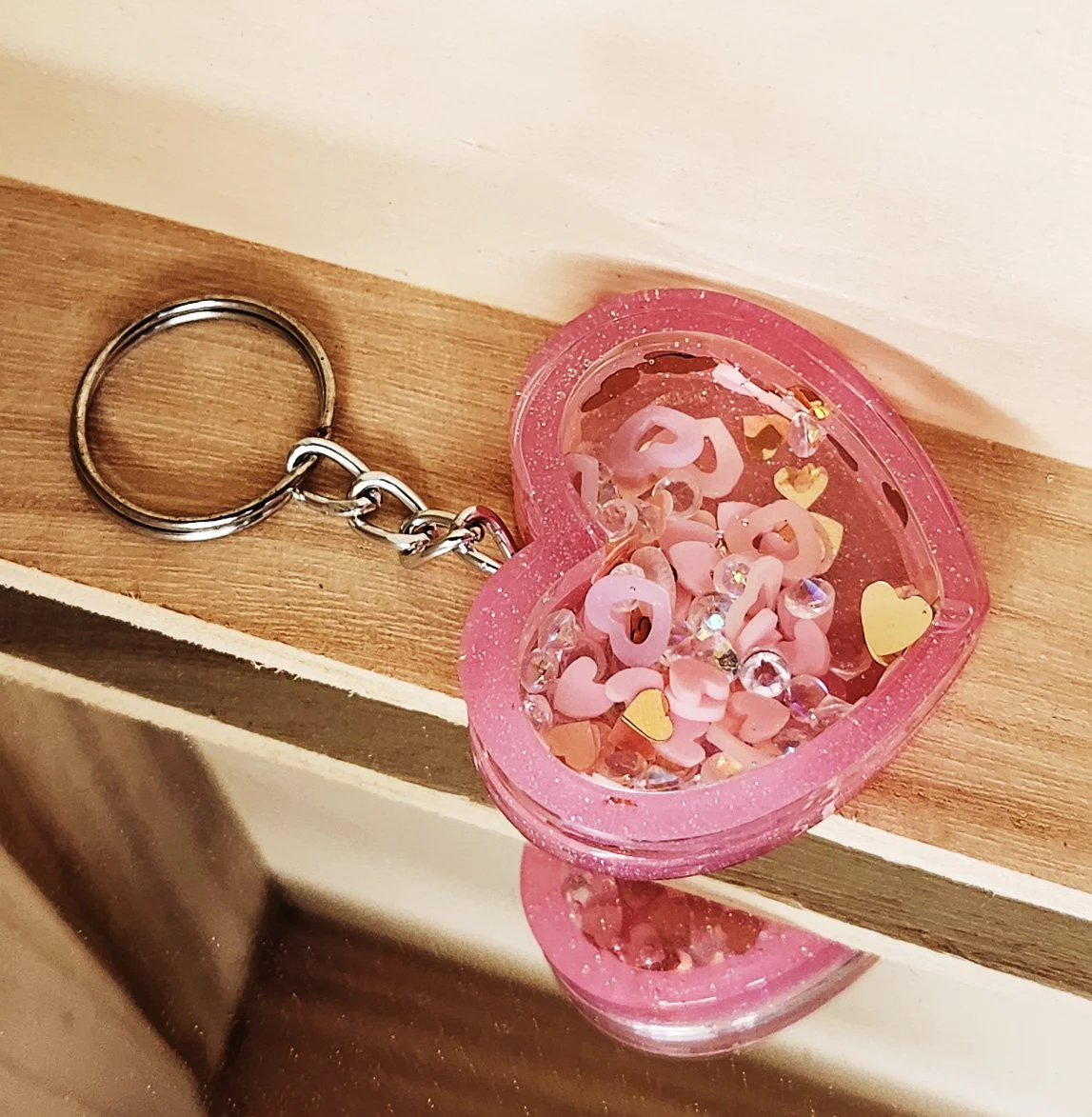 Sweetheart dry shaker keychain
Pink resin heart with clear resin heart topper filled with glitter, rhinestones, and foam heart cutouts