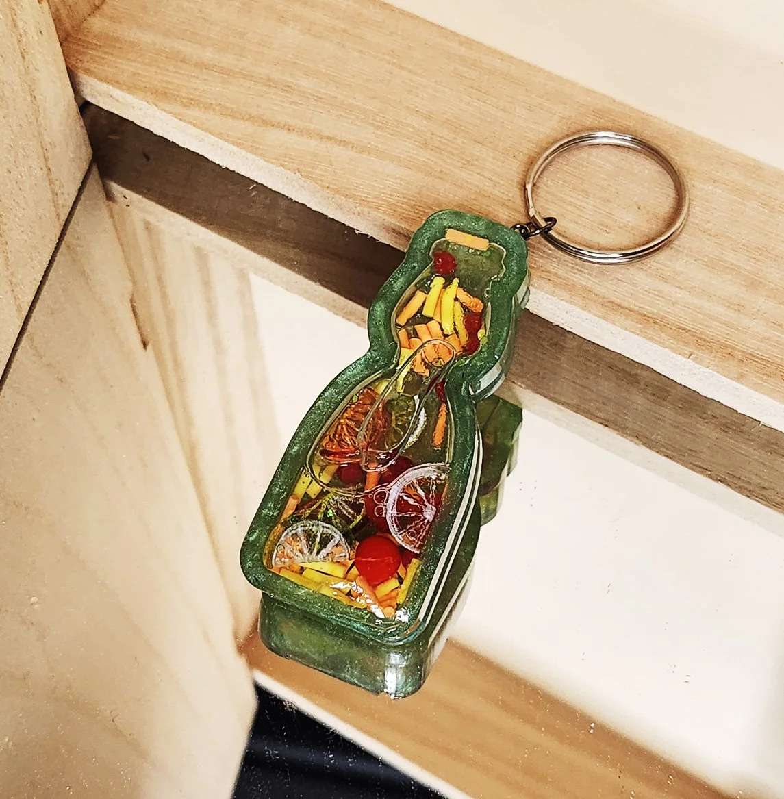 Citrus ramune wet shaker keychain
Green resin bottle with clear resin sealer top, filled with plastic citrus slices, foam sprinkles, and resin strawberries (inner liquid is baby oil)