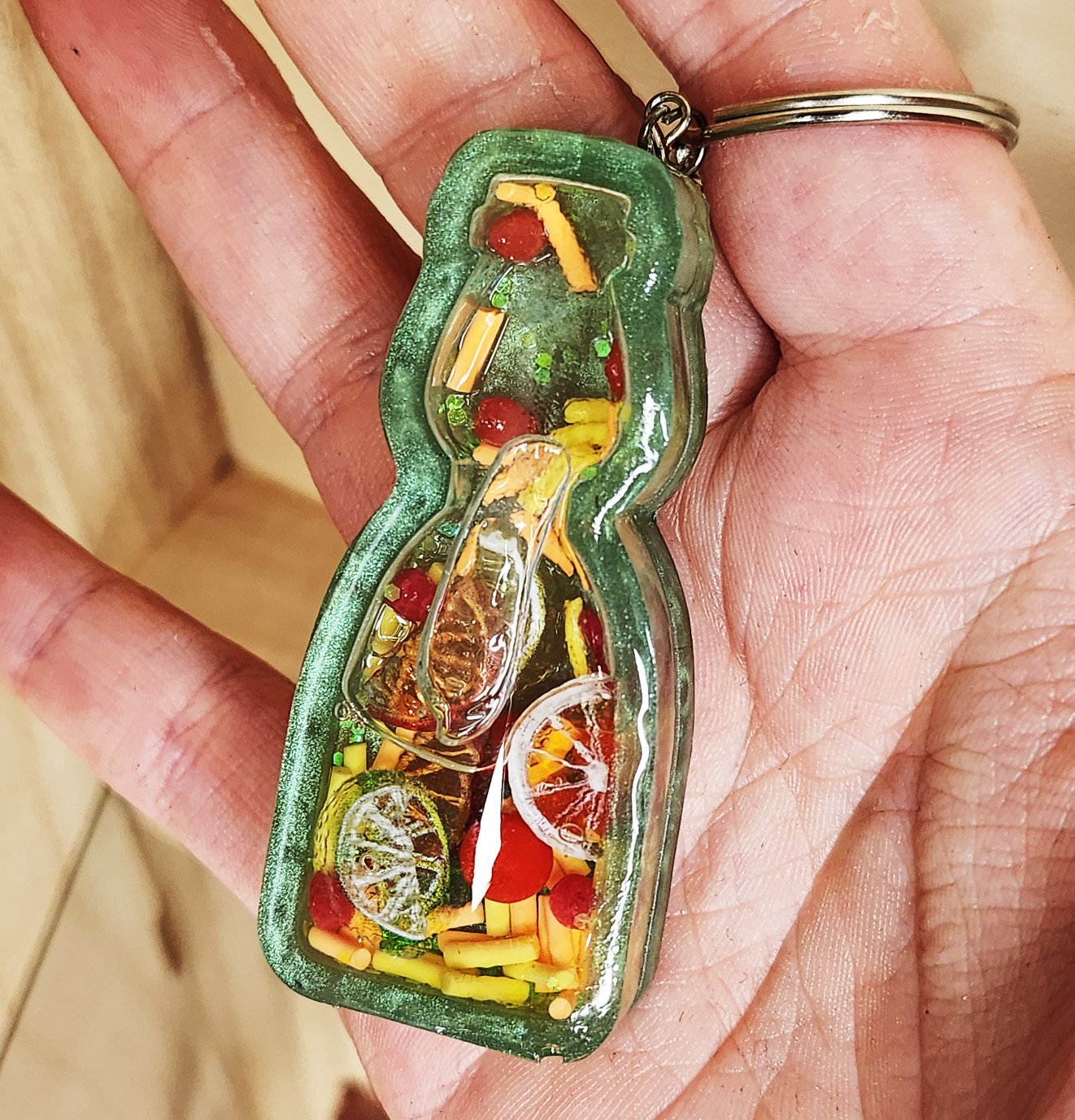 Citrus ramune wet shaker keychain
Green resin bottle with clear resin sealer top, filled with plastic citrus slices, foam sprinkles, and resin strawberries (inner liquid is baby oil)