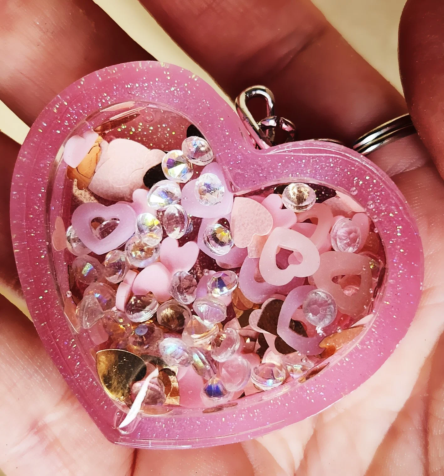 Sweetheart dry shaker keychain
Pink resin heart with clear resin heart topper filled with glitter, rhinestones, and foam heart cutouts