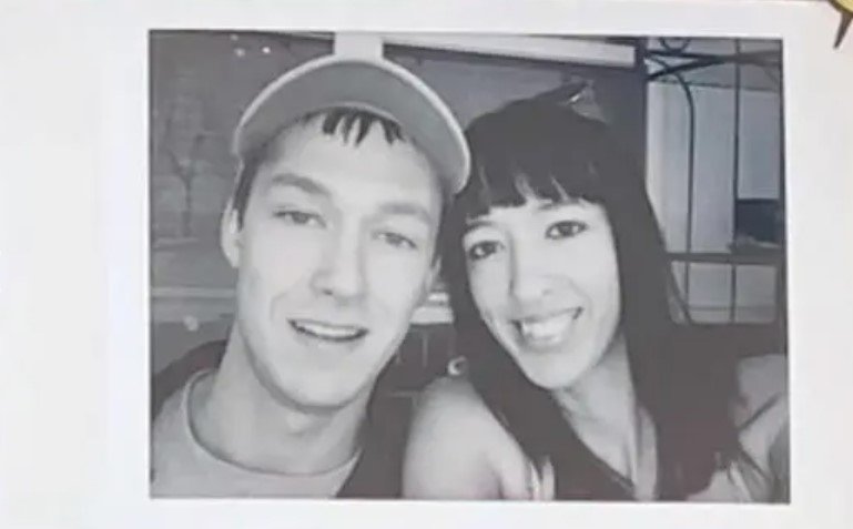Smiling man and woman taking a selfie in black and white.
