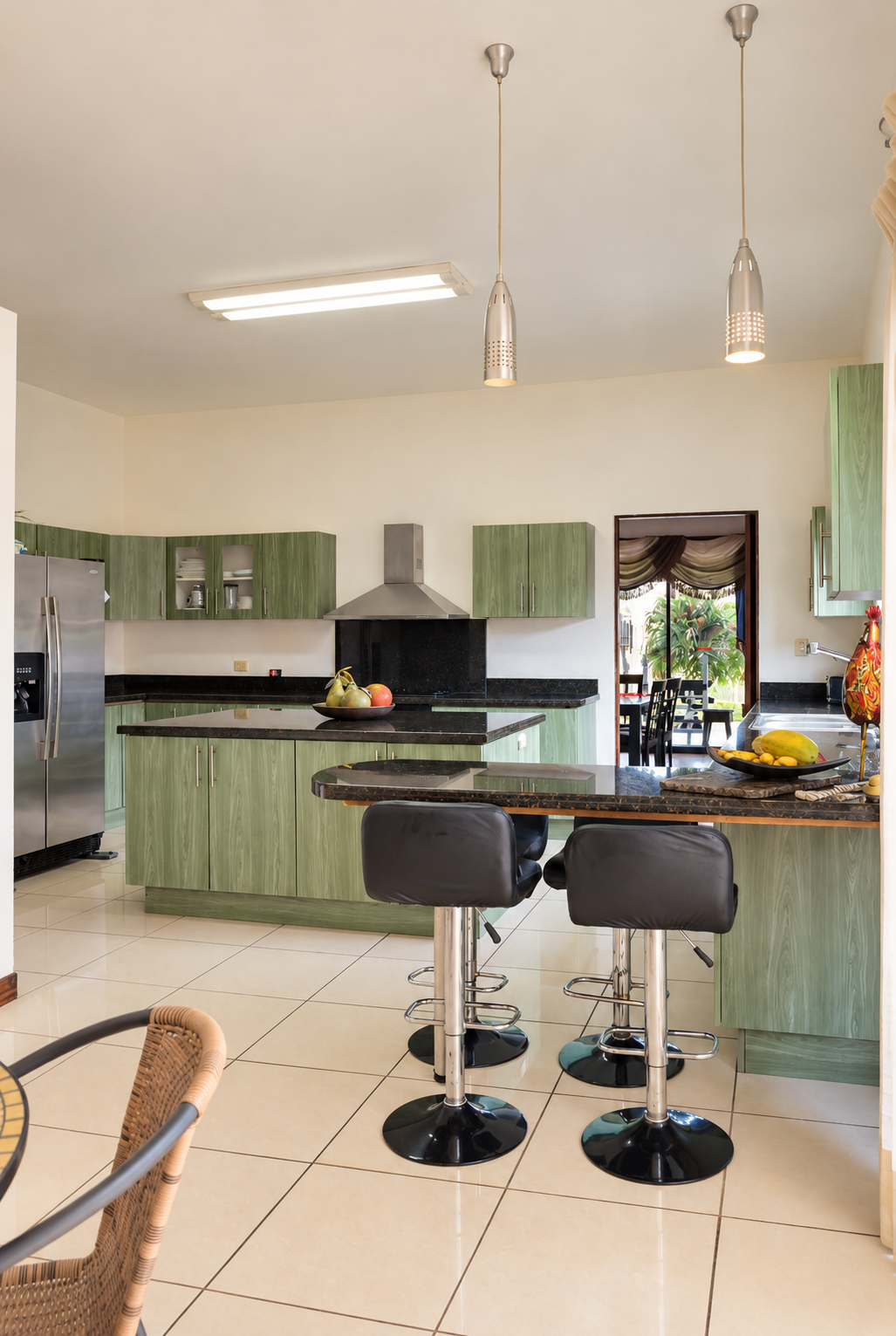 Cocina moderna verde con isla y barra.png