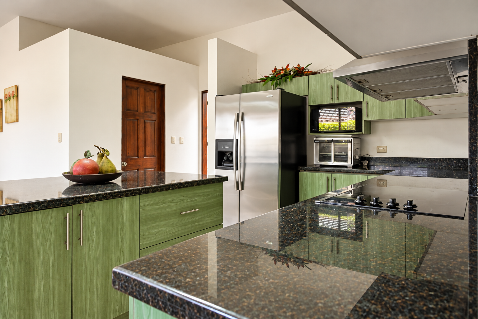 Cocina moderna verde con isla y fruta.png