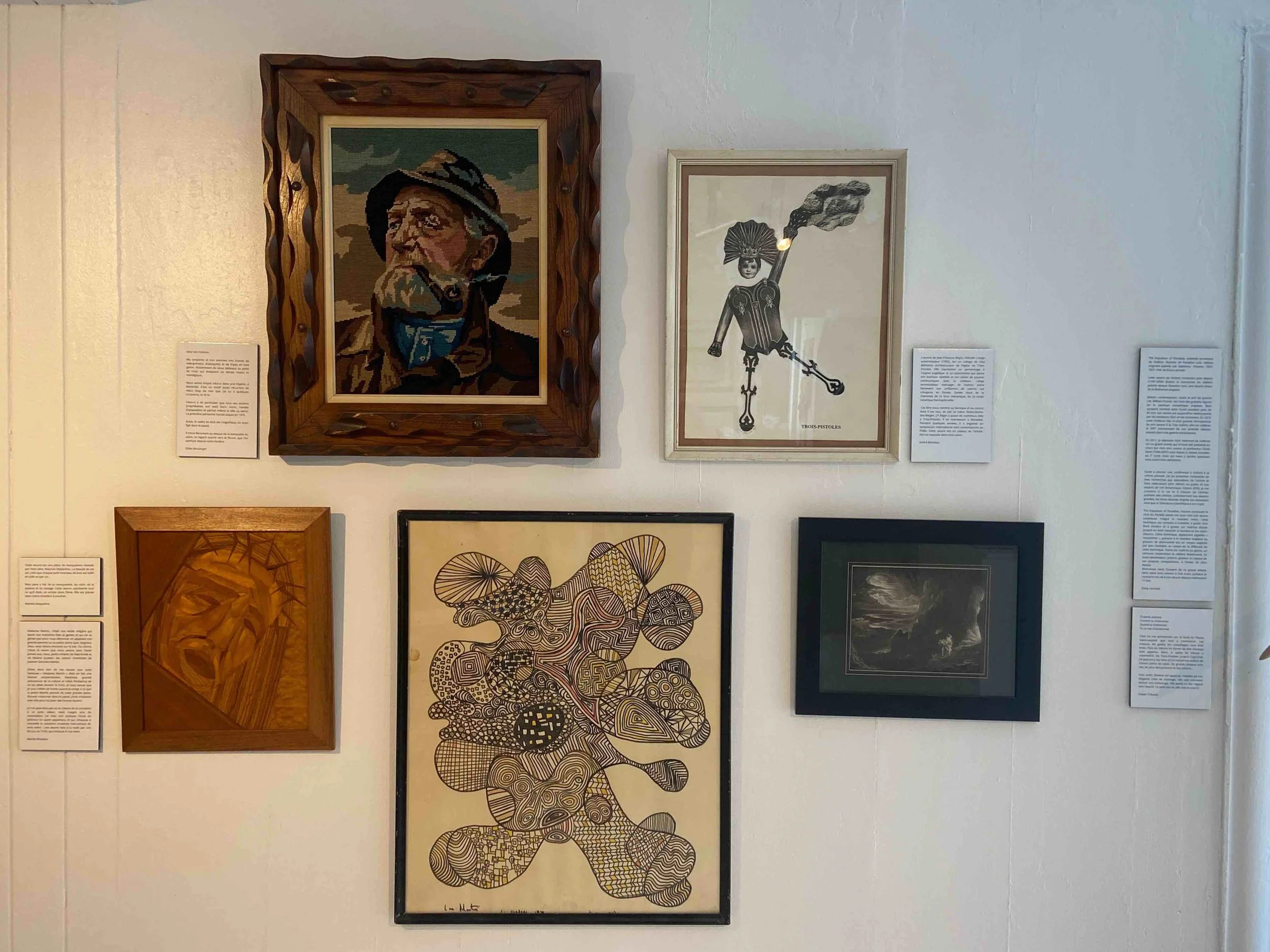 Projetions d'une galerie d'art avec six œuvres encadrées de styles variés, comprenant des portraits, une caricature, une œuvre abstraite et un paysage nocturne.