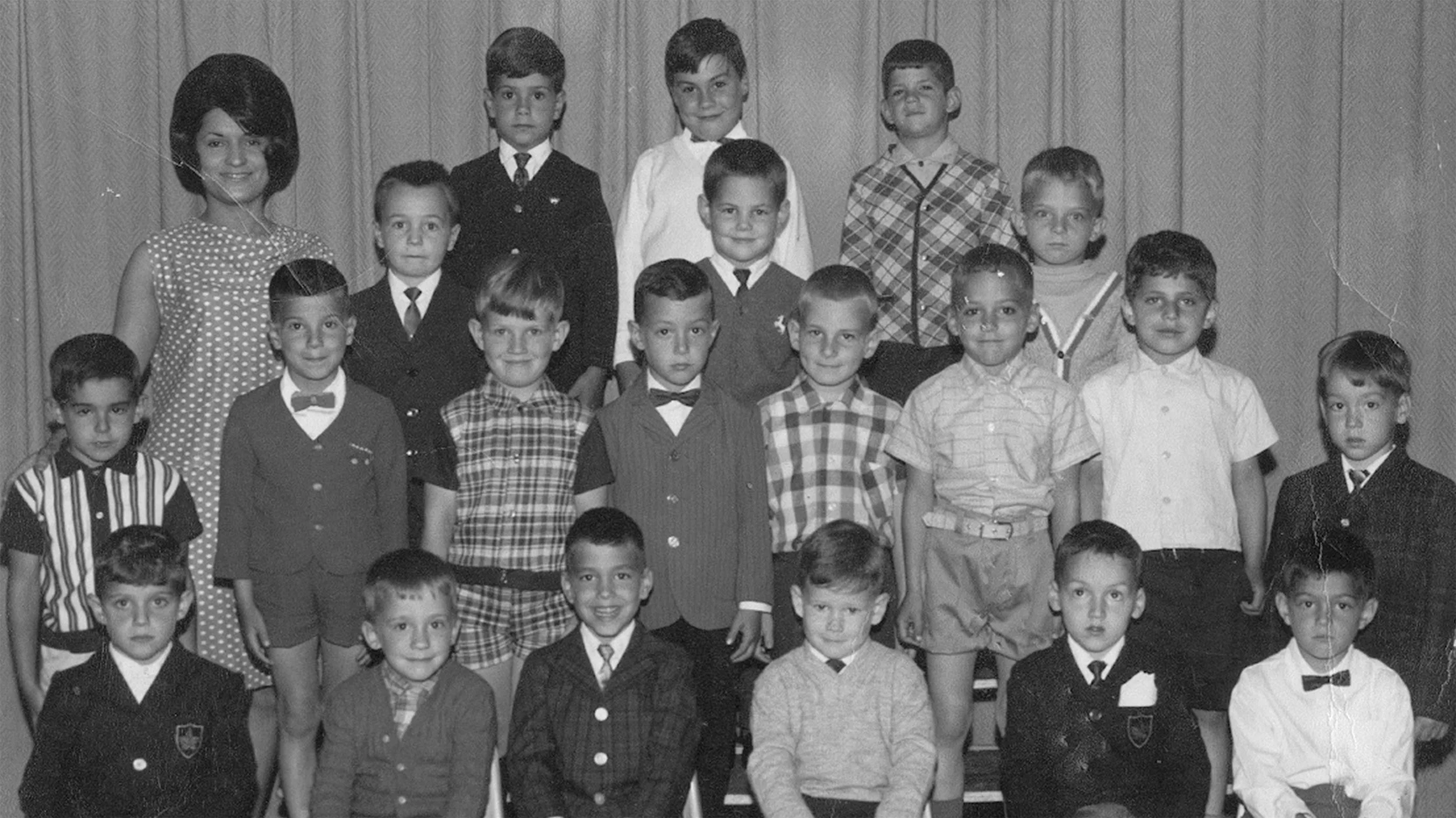 Photo en noir et blanc d'une classe d'élèves et leur professeur posant pour un portrait scolaire.