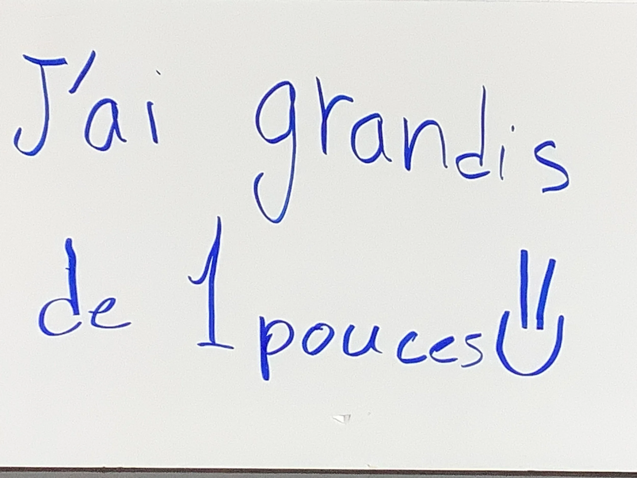 Message écrit à la main en français : « J'ai grandi de 1 pouce » avec un smiley