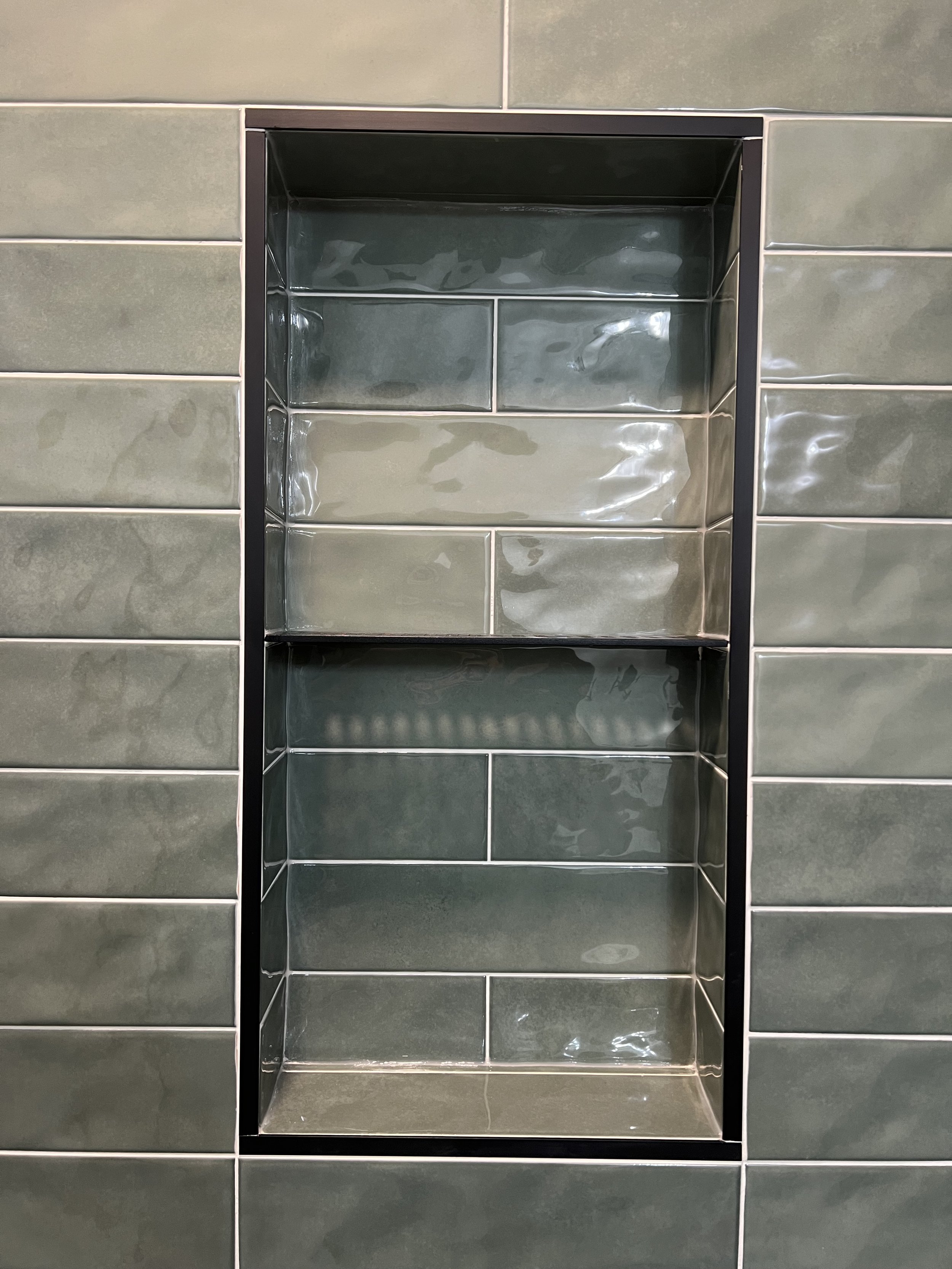 Green tile shower niche with shiny finish