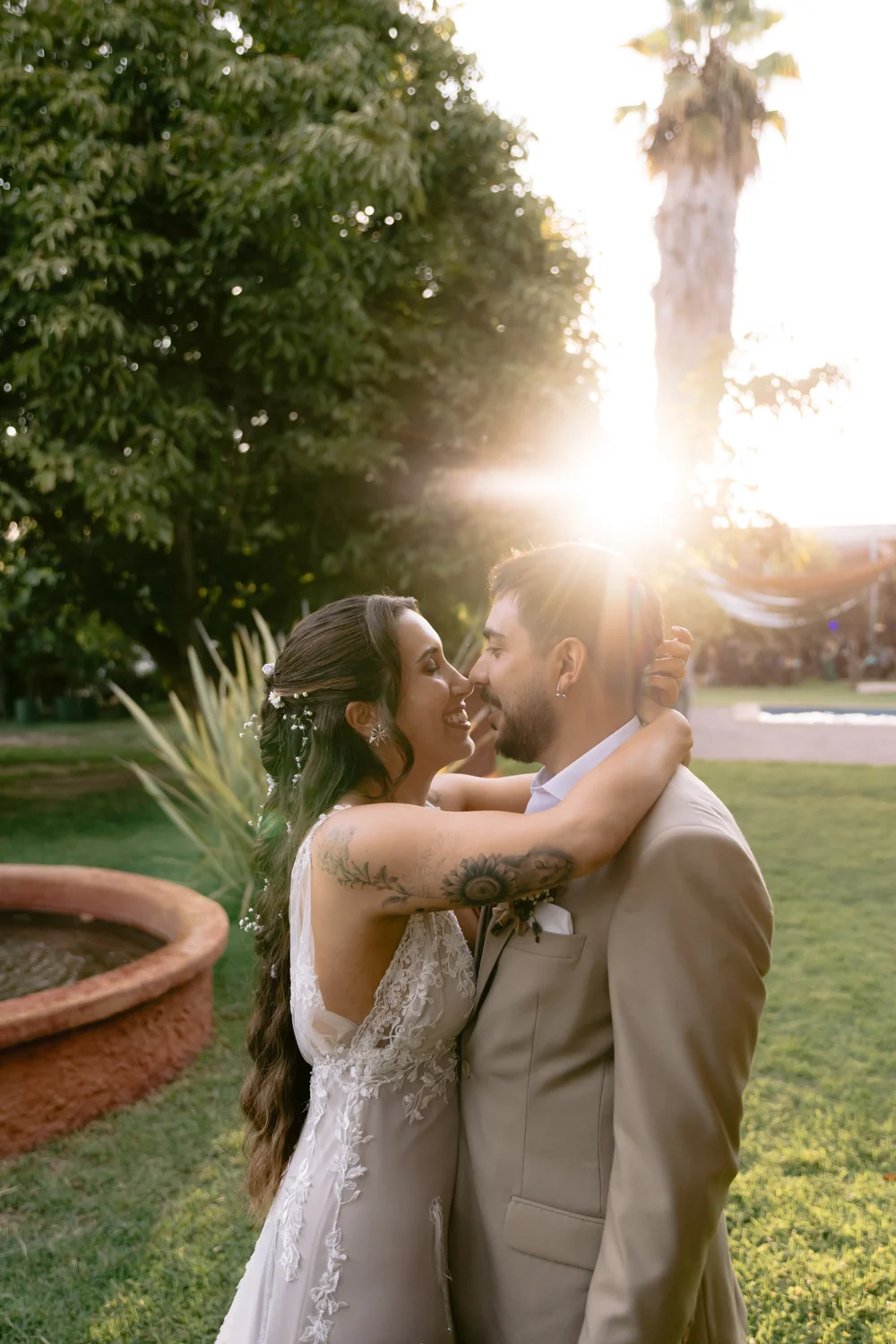Los novios abrazados contra el sol del atardecer