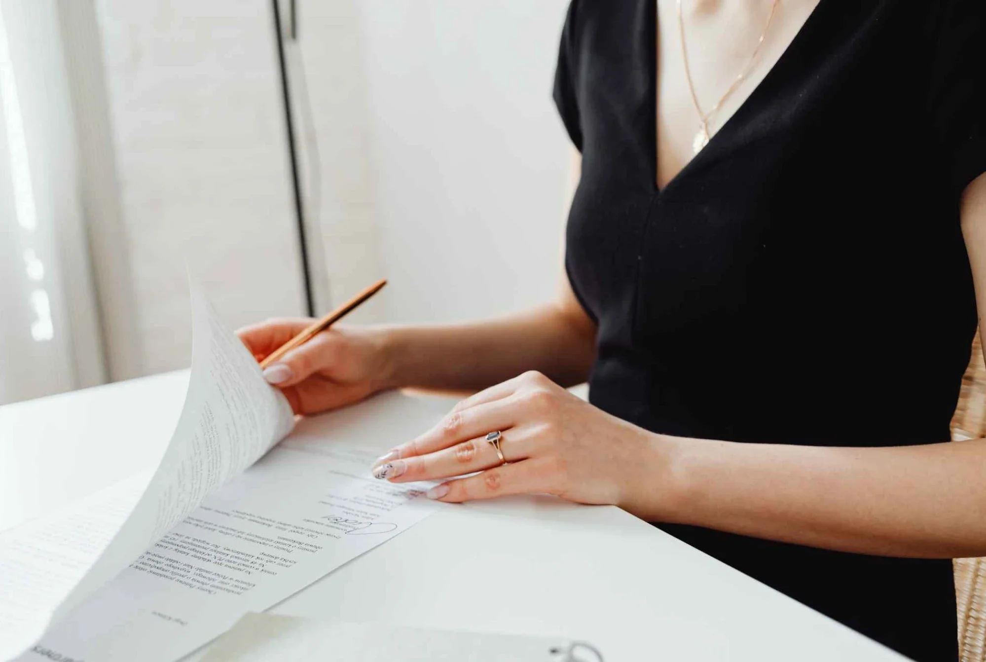 Business owner signing incorporation documents to set up a holding company in Canada.