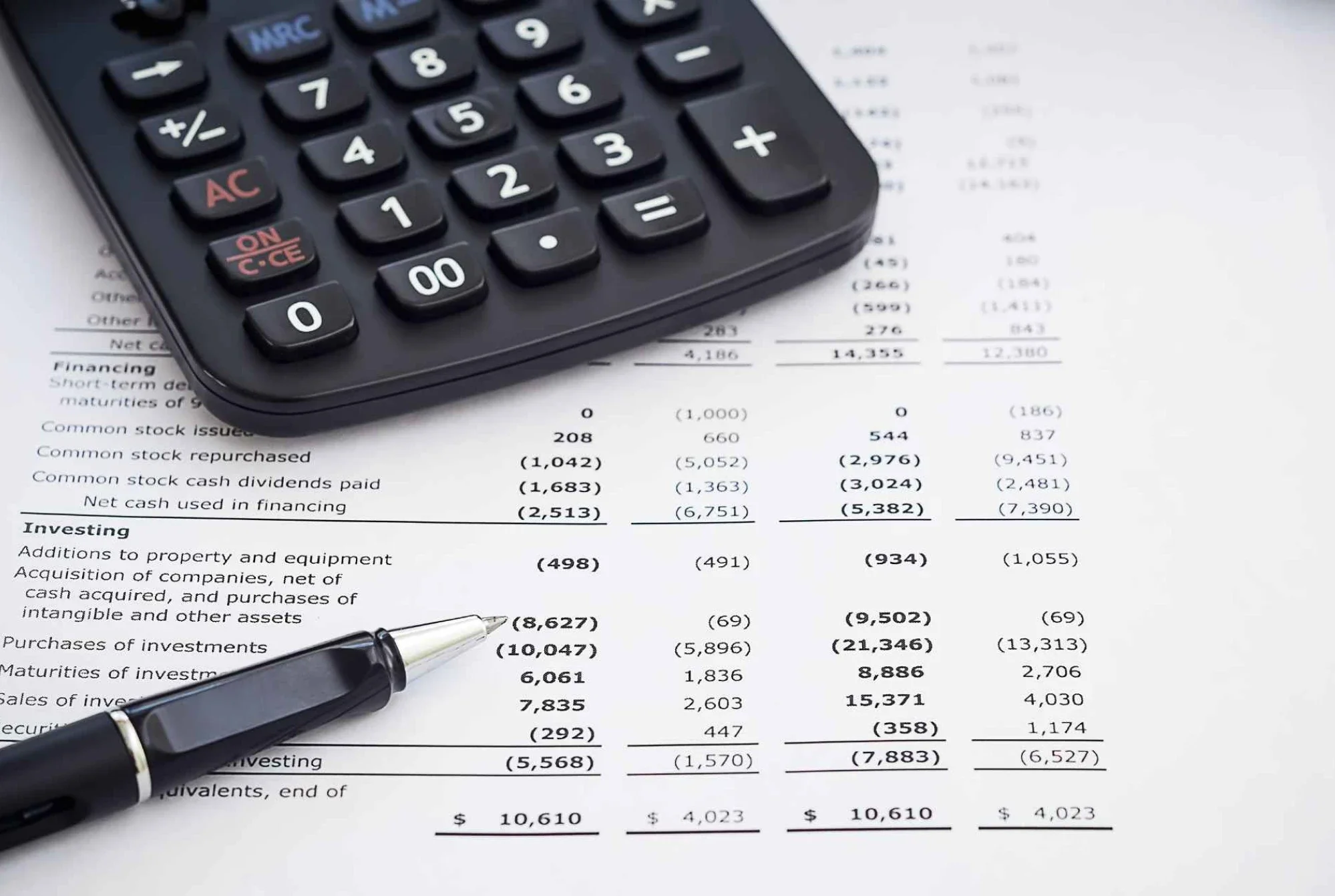 Calculator and pen on a financial statement used to track cash value life insurance growth