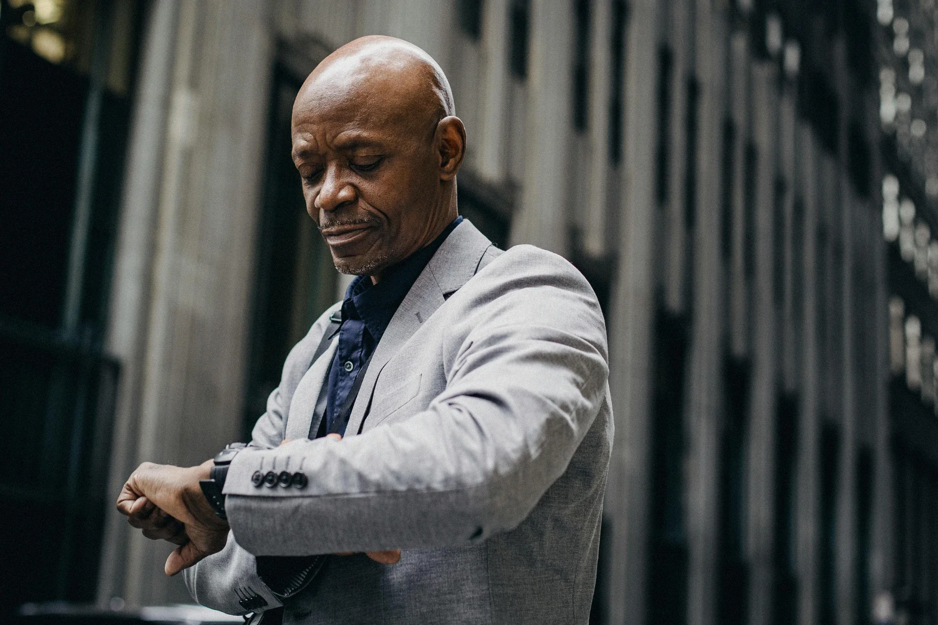 Businessman looking at his watch while outside a building