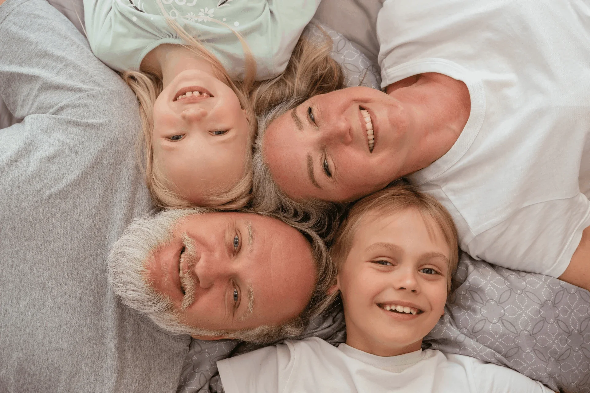 Grandparents and grandkids smiling and looking up at the camera