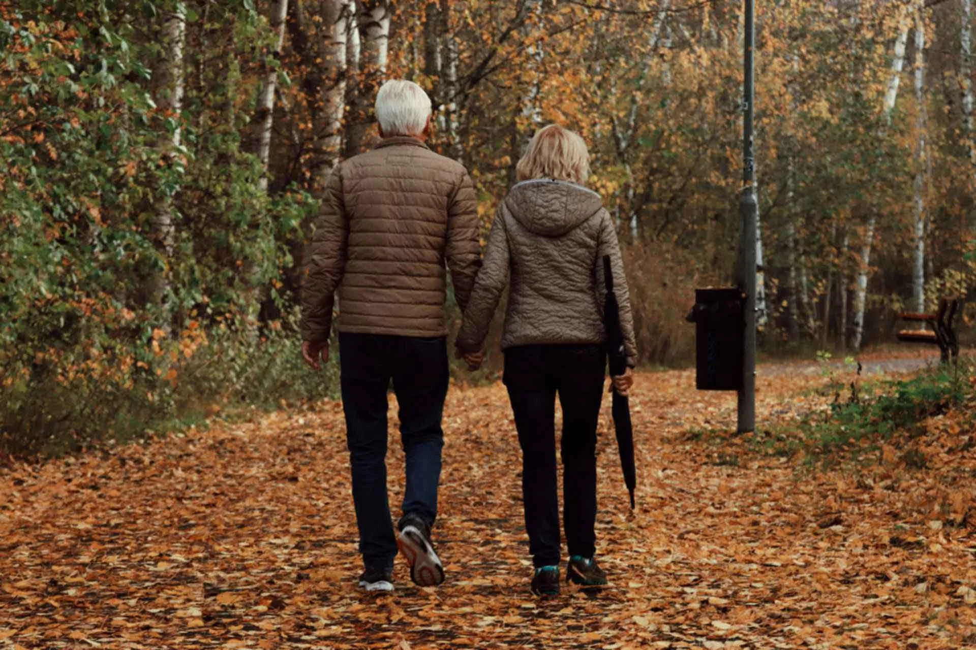Retired couple walking hand in hand outdoors, enjoying life after retirement planning in Canada