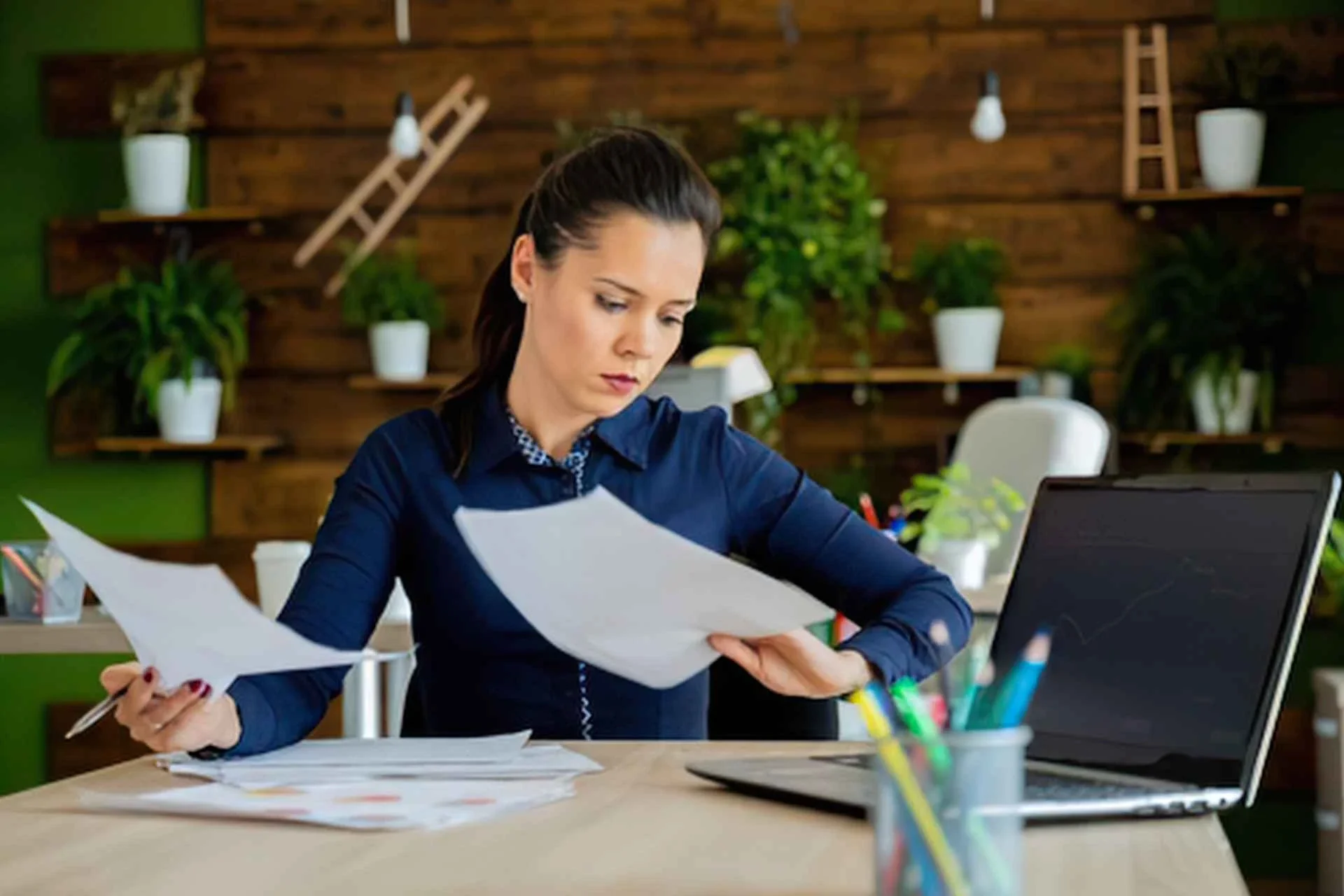 Canadian business owner reviewing holding company investment statements at a desk.
