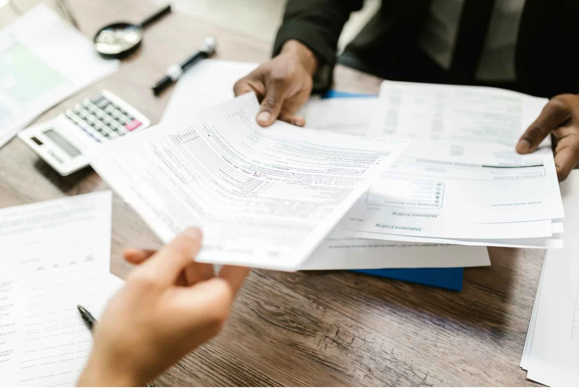 Advisor handing a business owner a participating whole life insurance policy statement at a desk