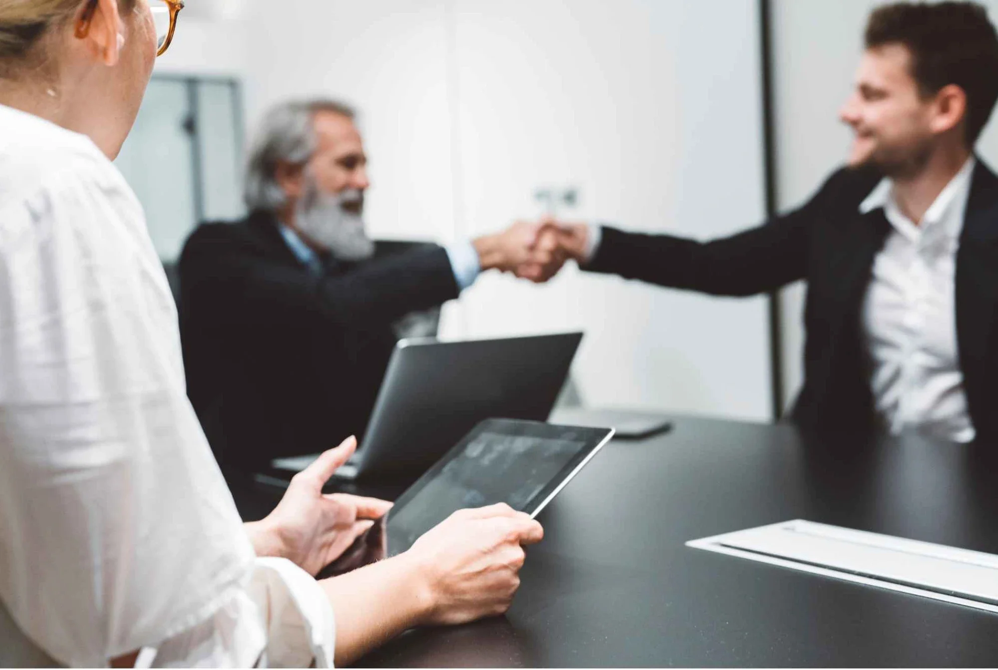 Business owner shaking hands with a successor during a succession planning meeting.