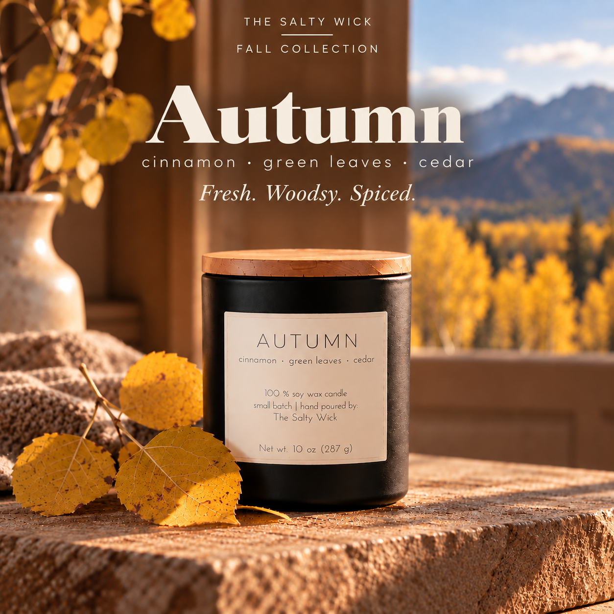 The Salty Wick Autumn soy candle with notes of cinnamon, green leaves and cedar, hand-poured in a matte black ceramic vessel with a natural wood lid.
