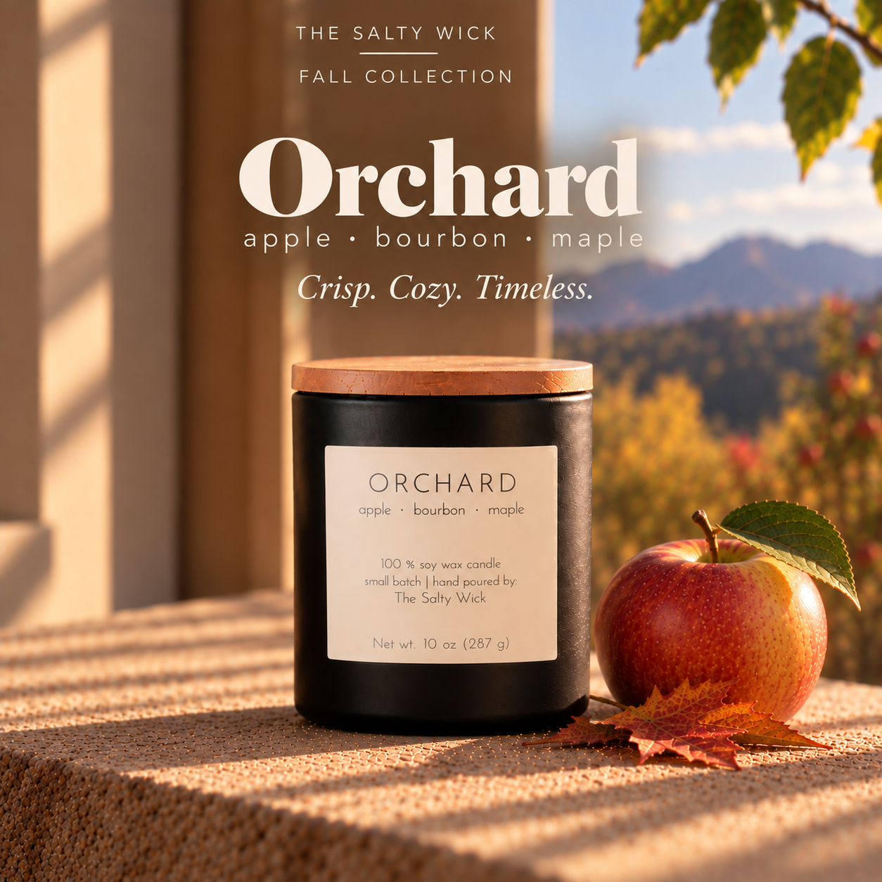 The Salty Wick Orchard soy candle with notes of apple, bourbon and maple, hand-poured in a matte black ceramic vessel with a natural wood lid.