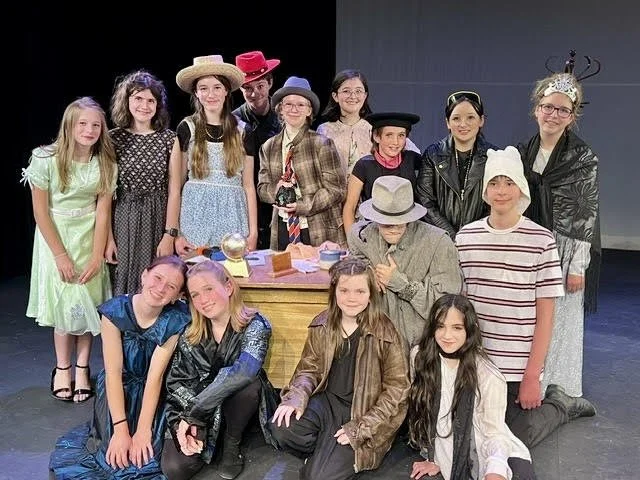 Group of students on stage posing after a show