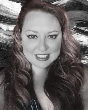 A smiling woman with wavy hair in front of a dark abstract background.