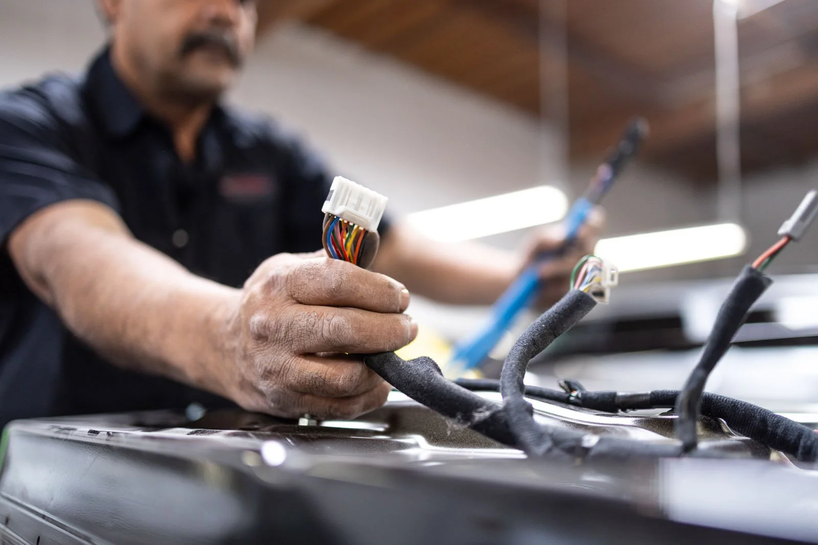 Technicians repairing a modern vehicle with advanced driver assistance systems at Prestige Bodyworks in Oxnard