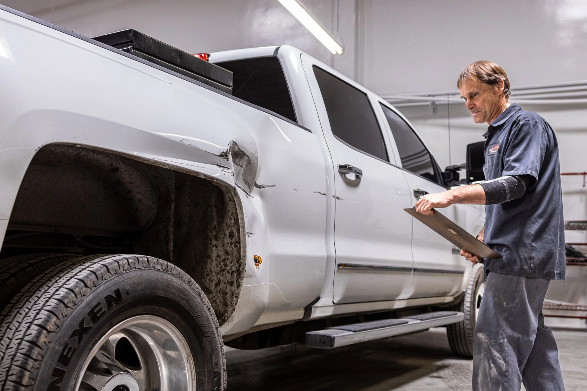 Technician inspecting collision damage for bent frame repair in Oxnard
