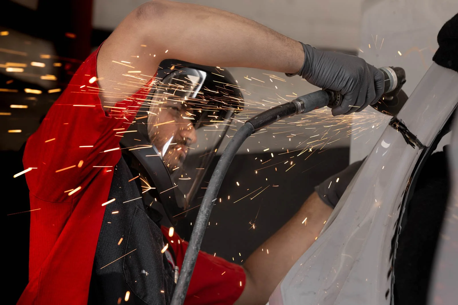 Technician performing structural collision repair on a vehicle in Oxnard