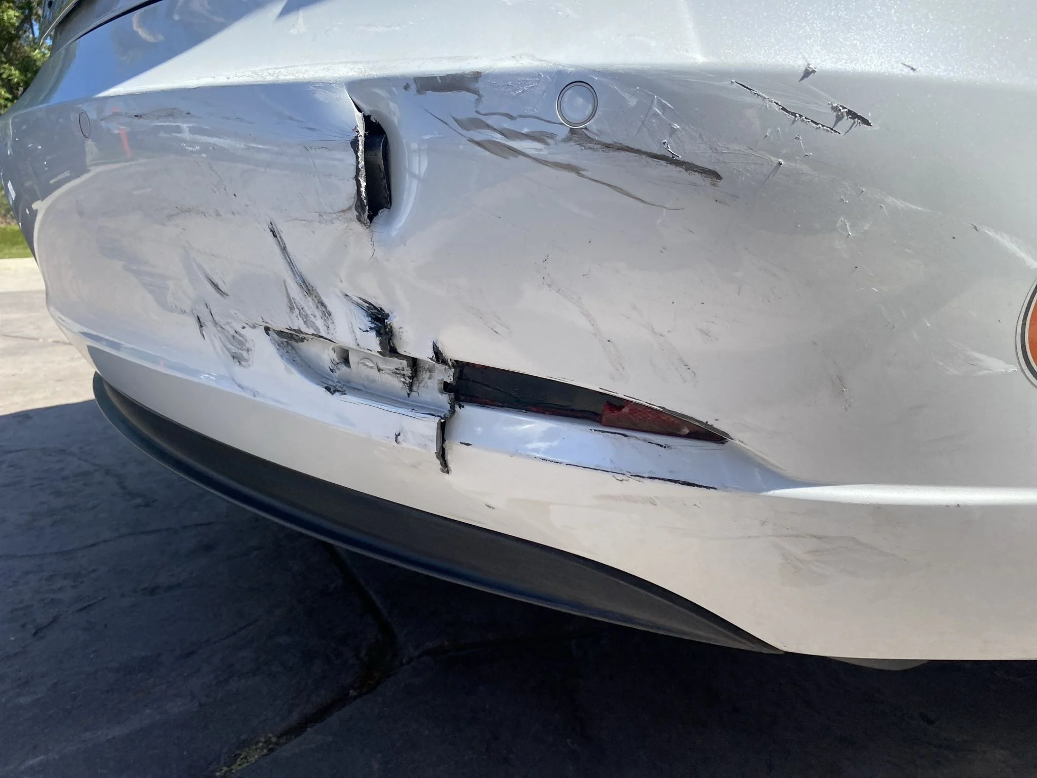 Visible rear bumper damage on a Tesla after a collision in Oxnard