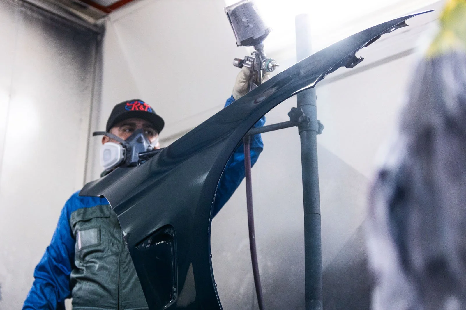 Auto body technician performing professional paint repair in Oxnard inside a controlled spray booth.